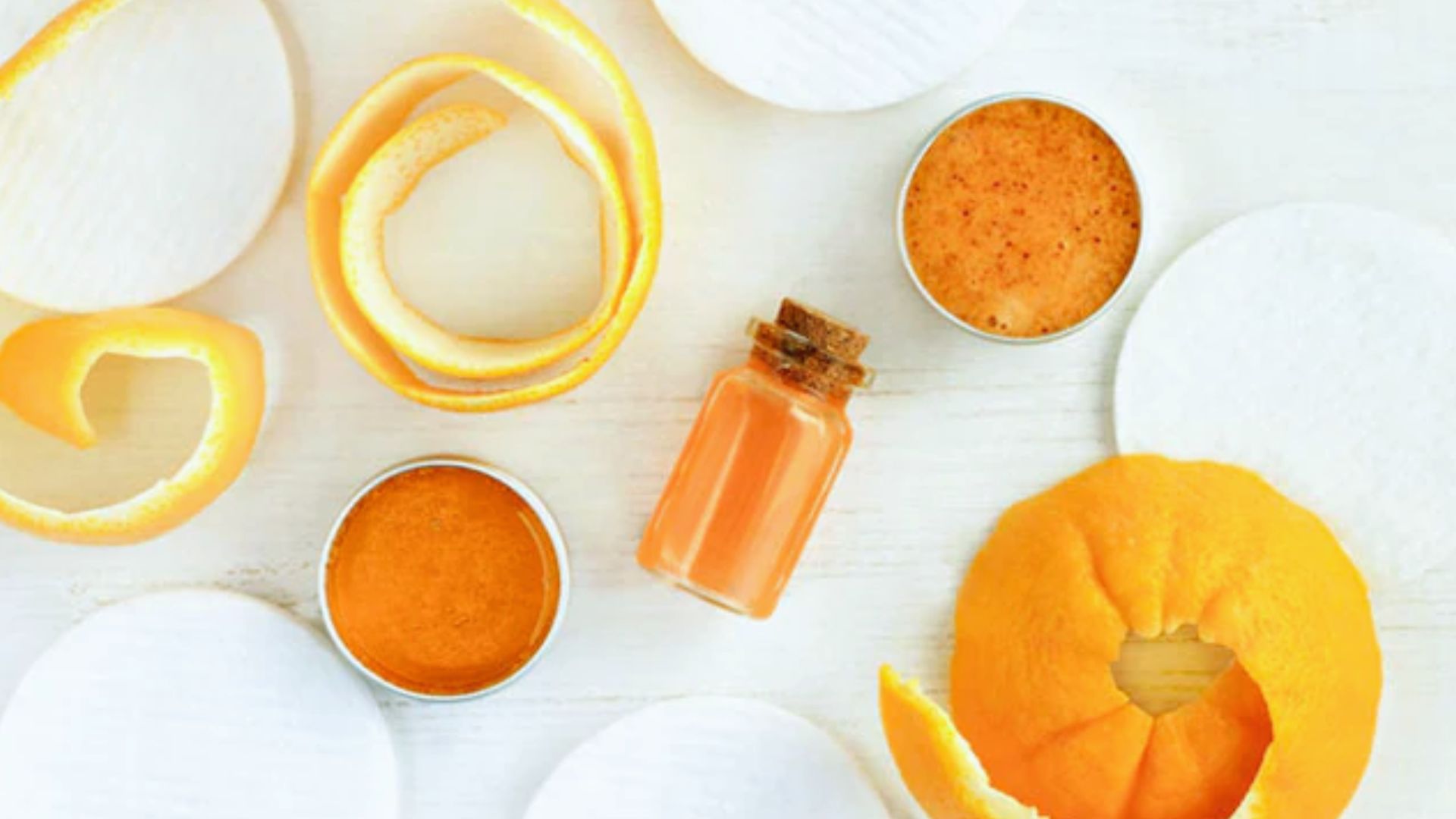 Orange peel and various ingredients arranged on a clean white surface, showcasing vibrant colors and textures.