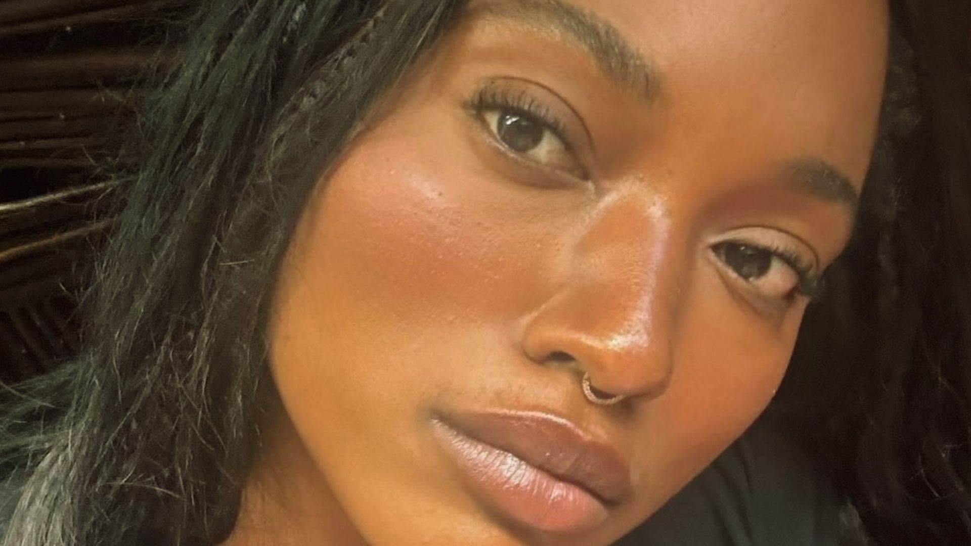 A woman displaying a nose piercing, highlighting her personal fashion choice.