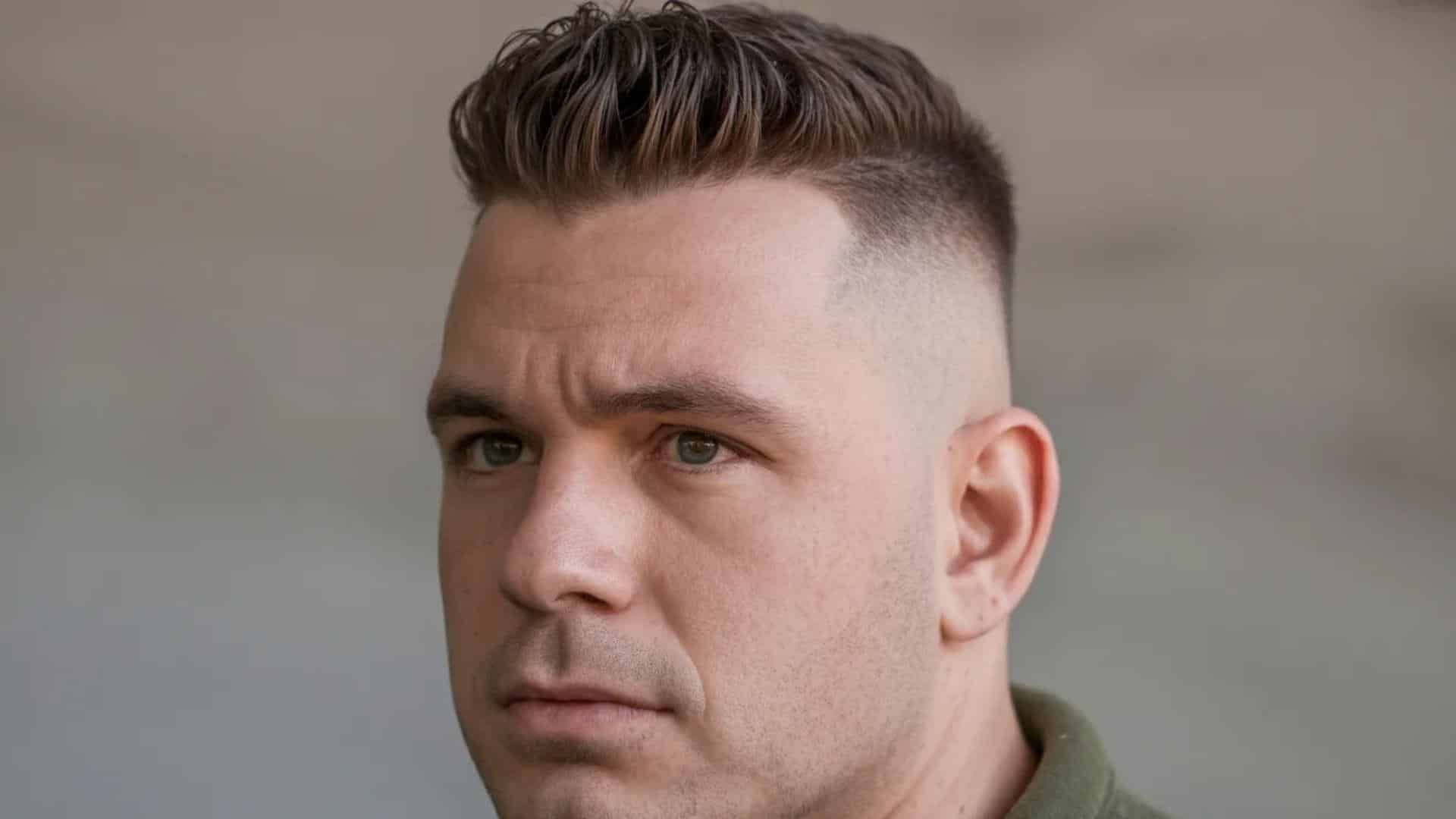 . A man with a short hairstyle turns his head to the side, observing his surroundings.