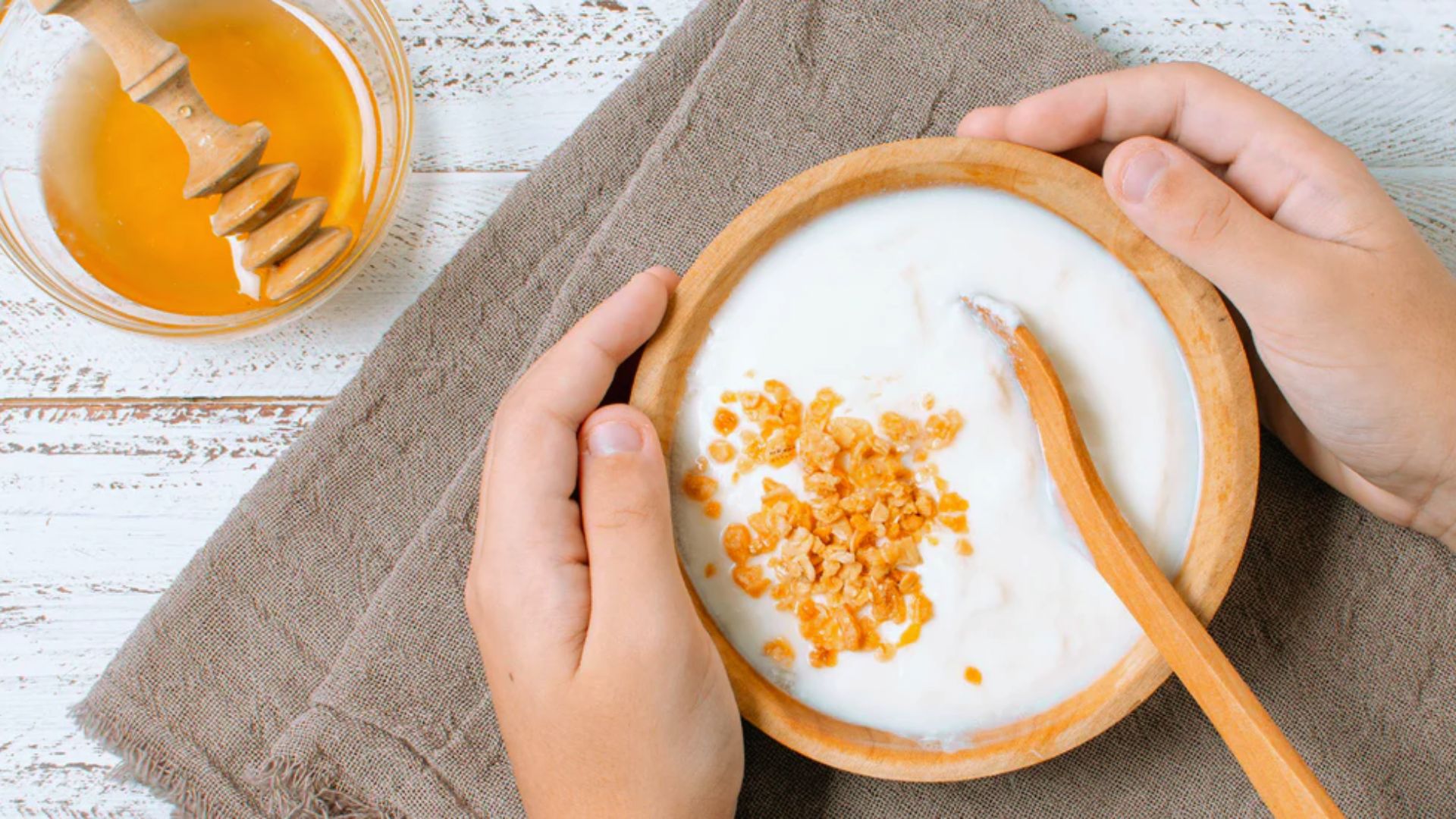 Creamy yogurt topped with golden honey and a piece of honeycomb, creating a sweet and textured dessert.