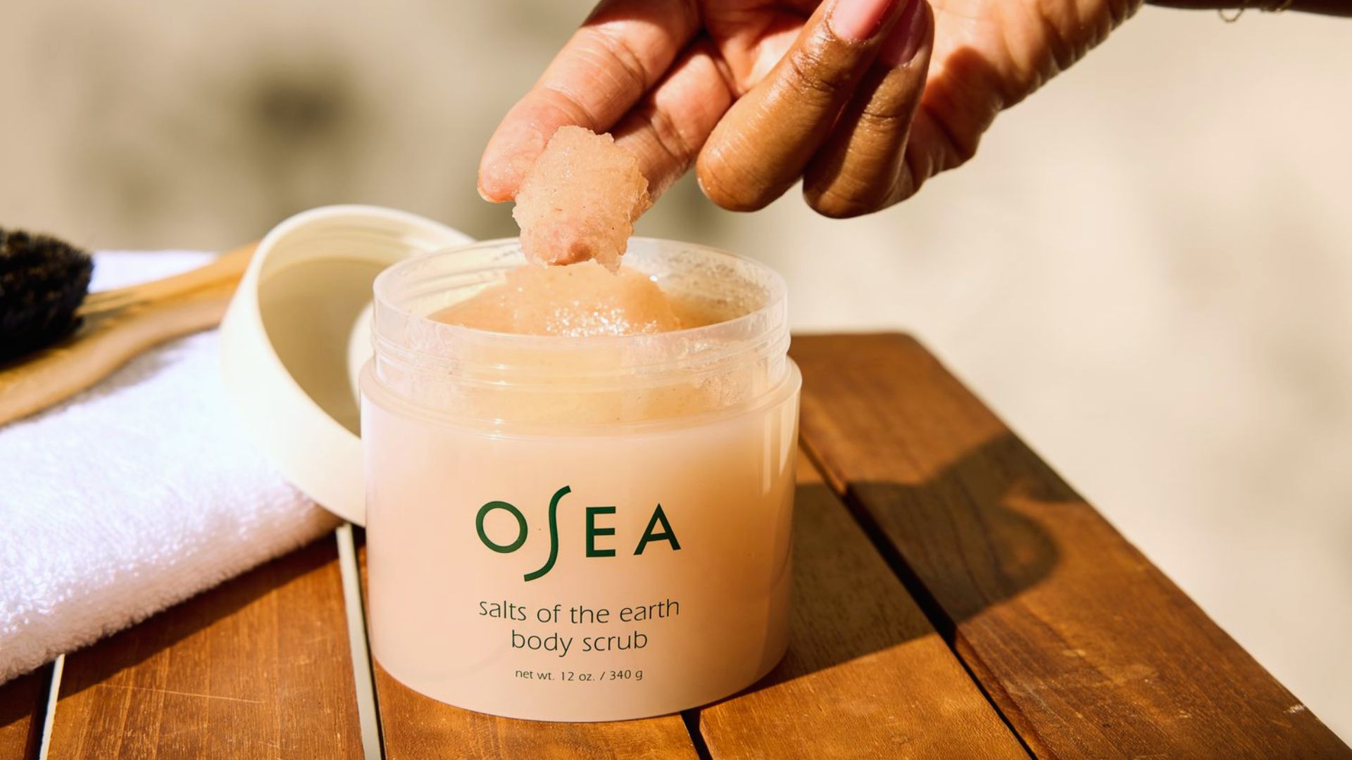 Osea salt scrub in a clear jar, showcasing coarse salt granules and a natural, earthy texture.
