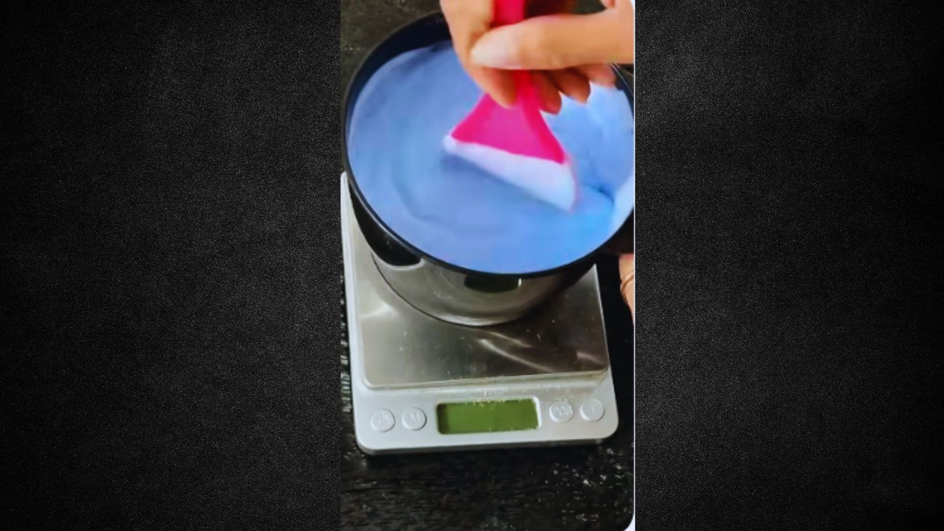A person cleaning a blue liquid with a pink brush, focusing on the task at hand.