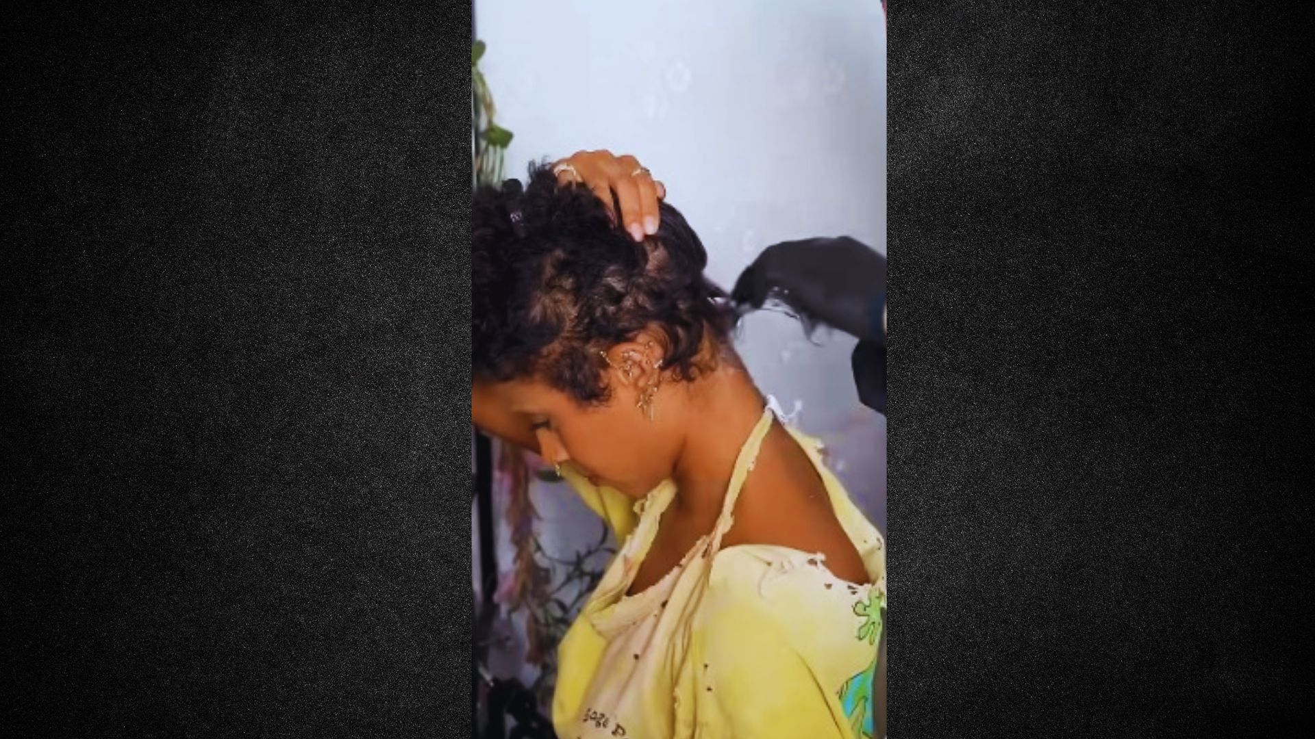 A woman relaxes as her hair is washed in a bright, modern bathroom setting.