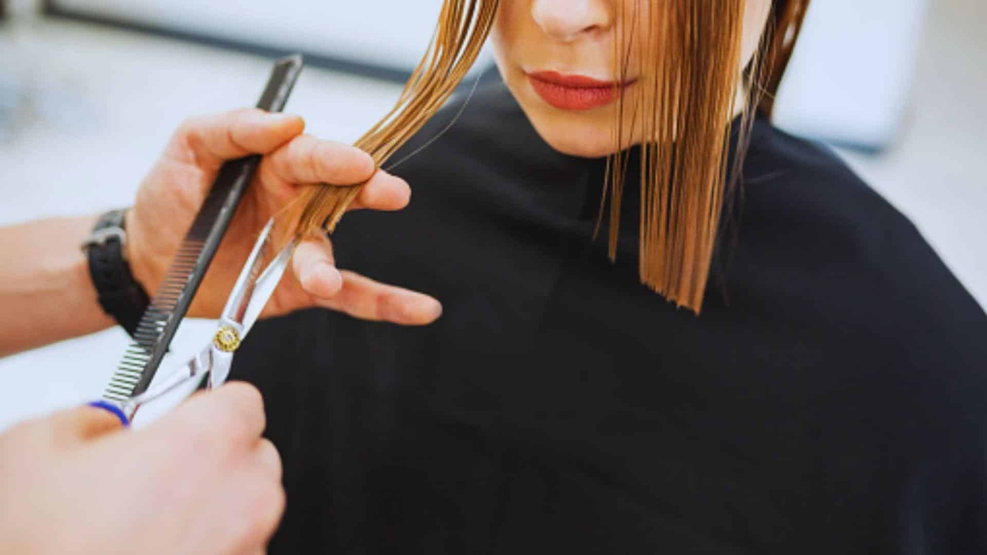 . A woman receives a haircut from a professional hairdresser in a stylish salon.