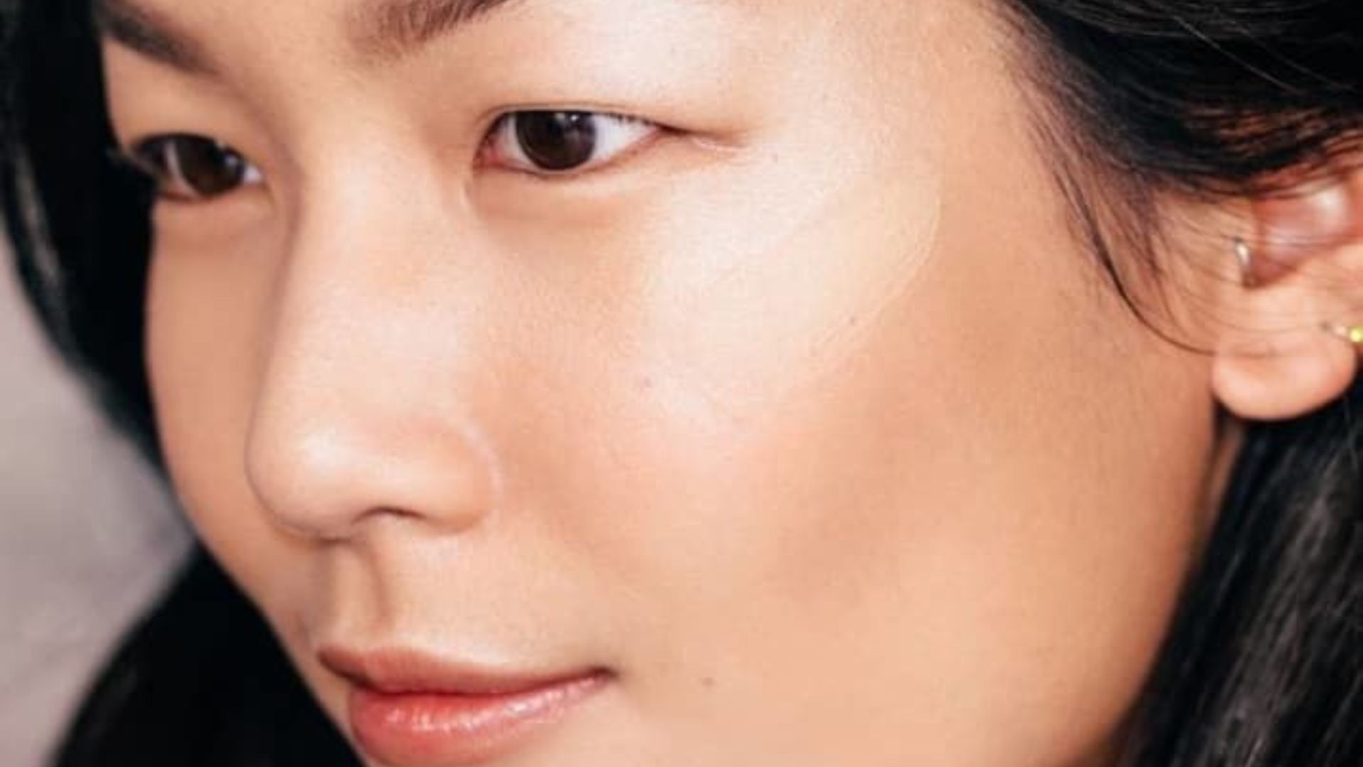 Close-up of a woman with long black hair, showcasing her facial features and hair texture.