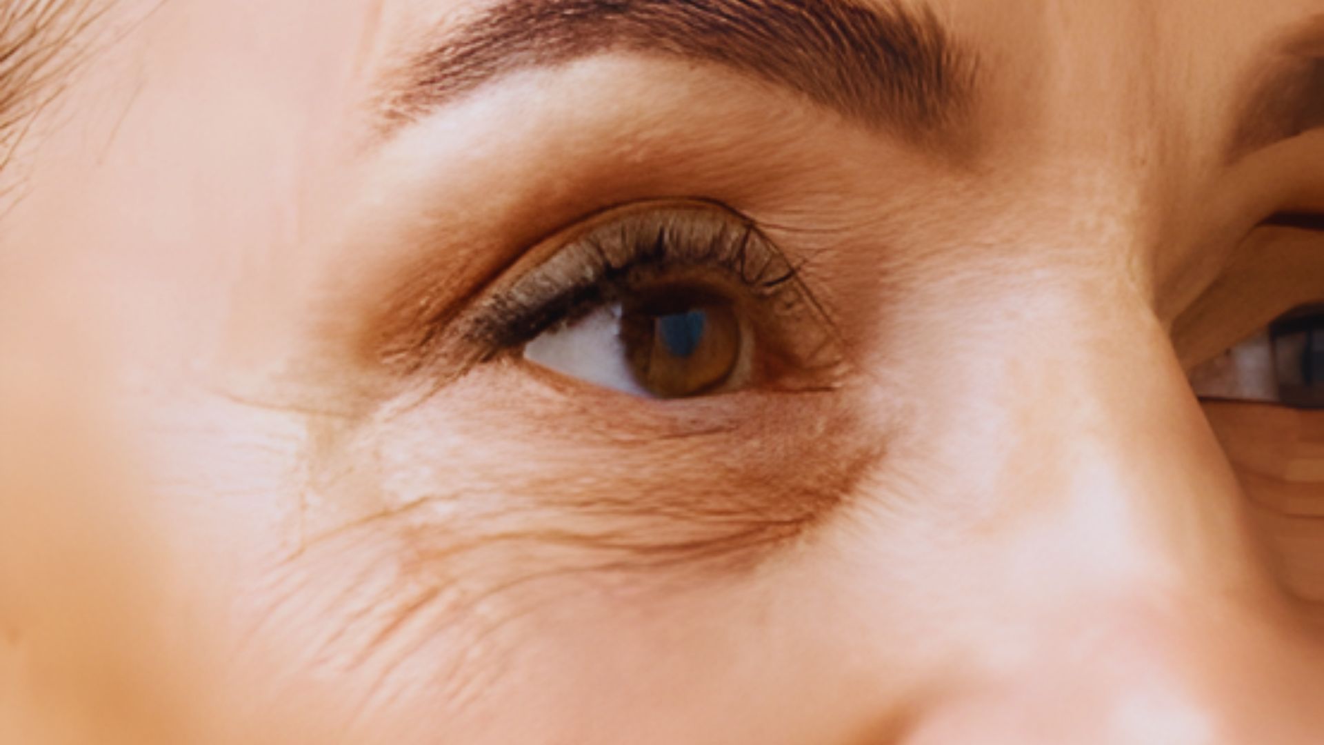 Close-up of a woman's eye, showcasing intricate details of the iris and eyelashes.