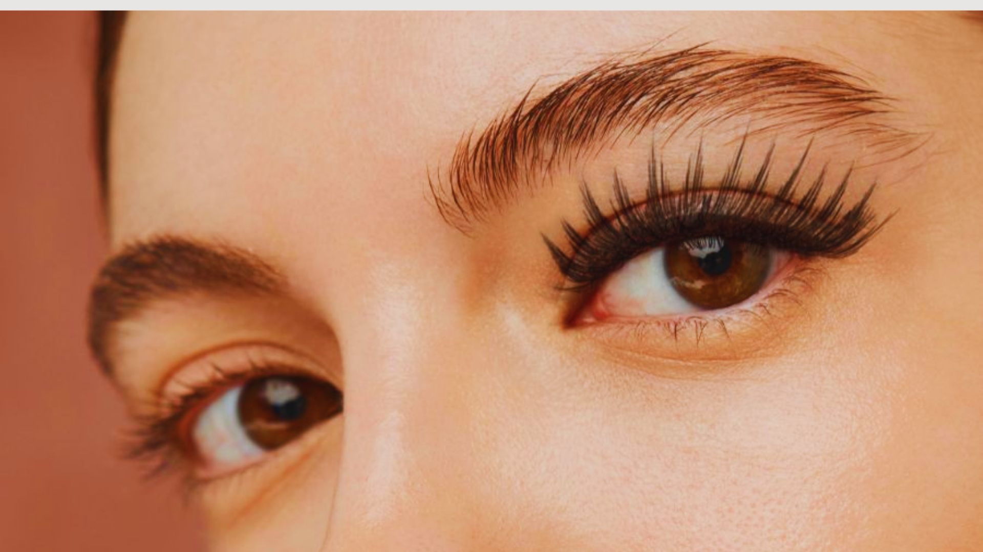 Close-up of a woman's face highlighting her expressive eyes and long eyelashes.
