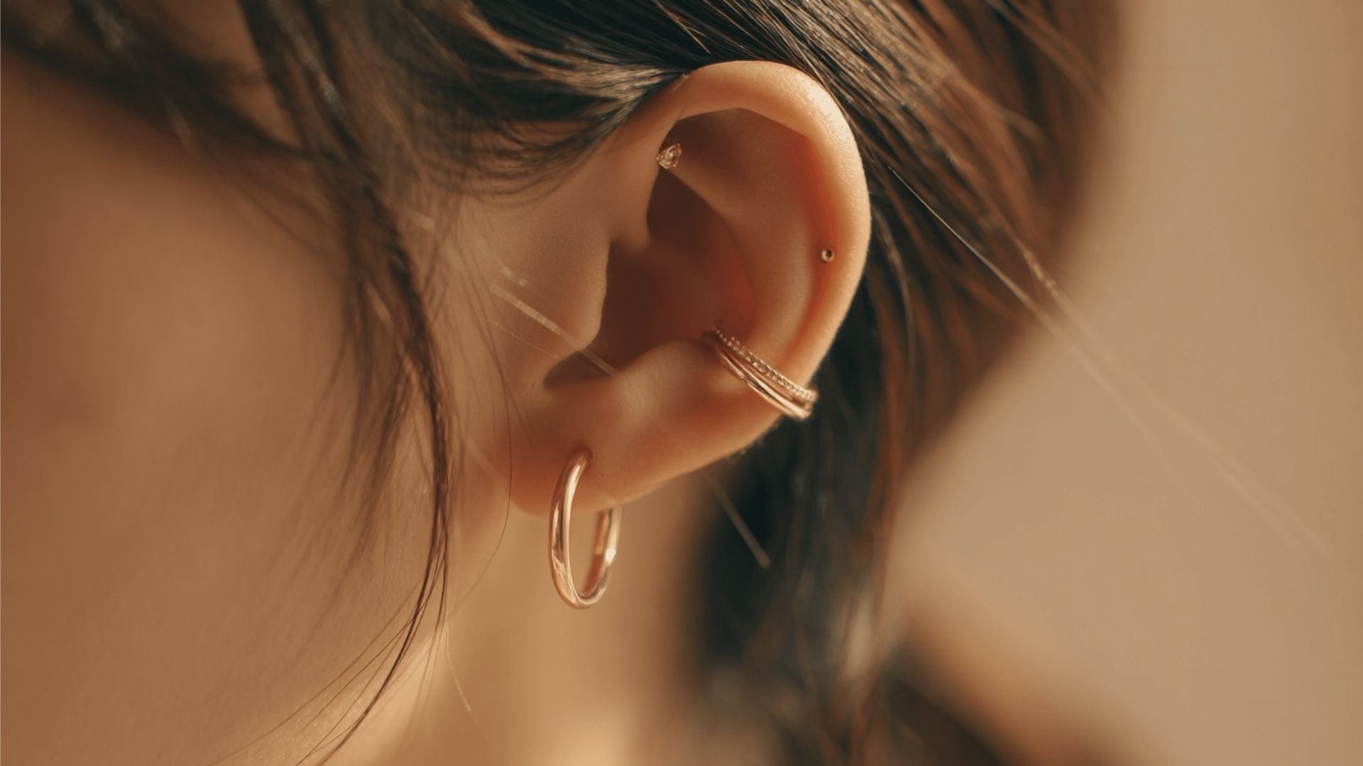 A woman wearing small hoop earrings, showcasing a stylish and elegant accessory.