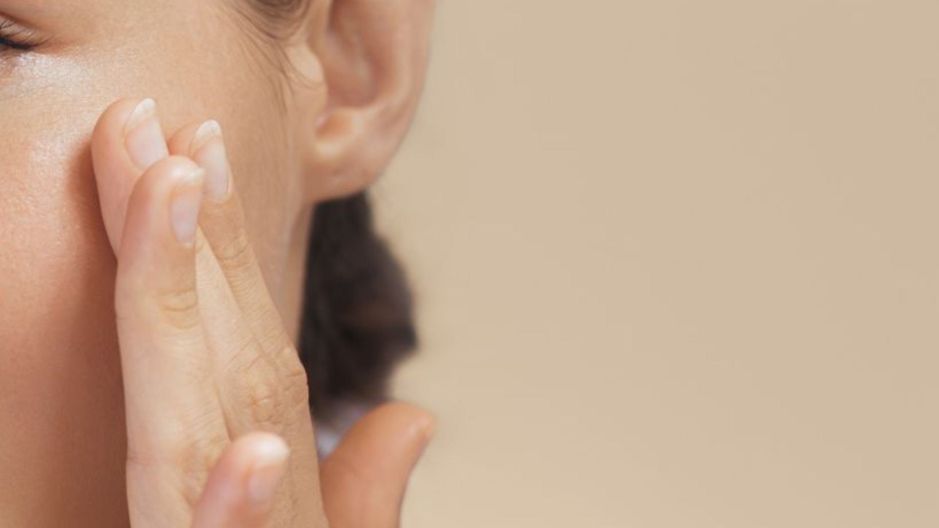 A woman with her hands on her face, indicating a moment of reflection or emotional response.