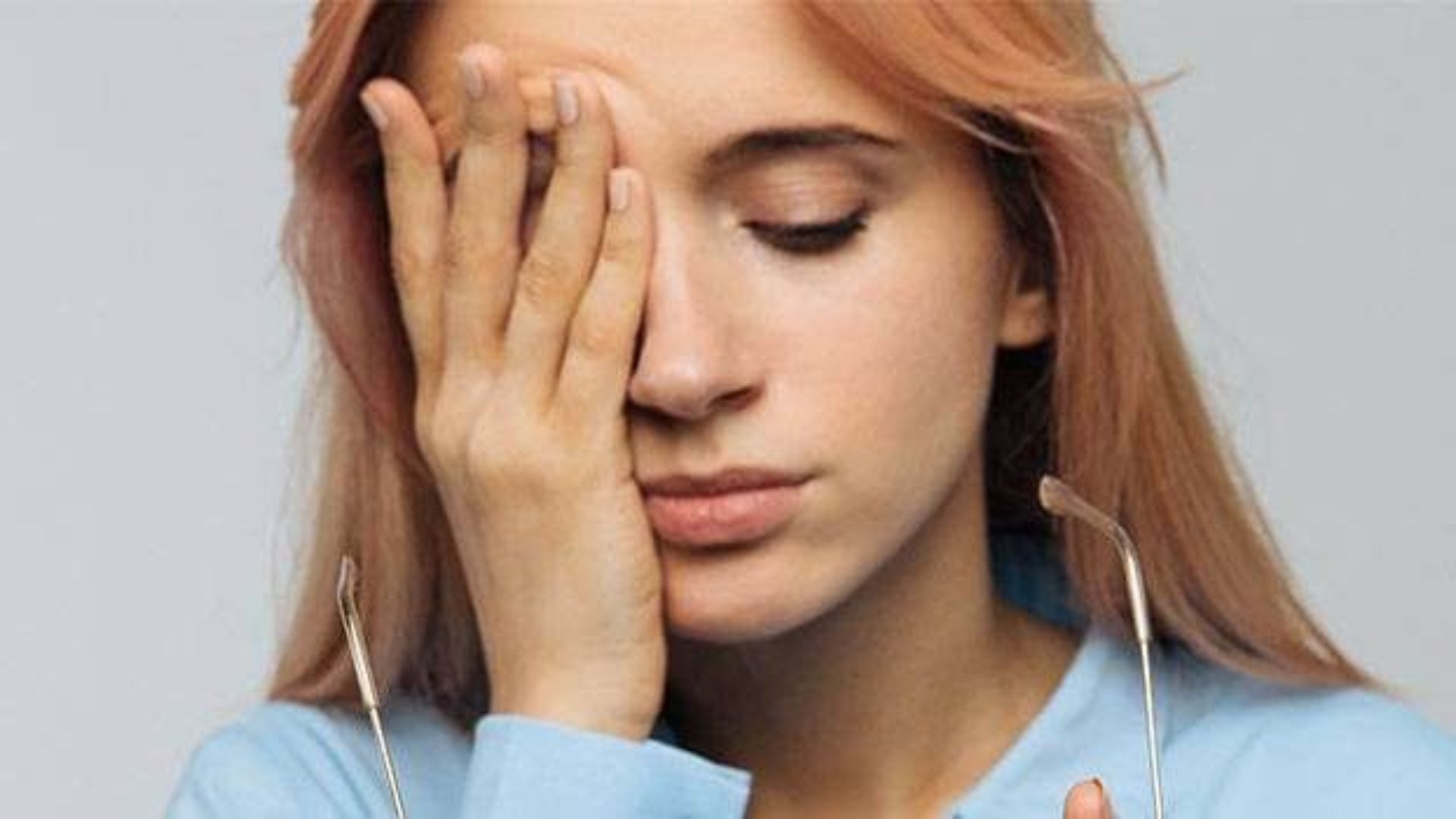 A woman with her hands on her face, expressing surprise or contemplation.