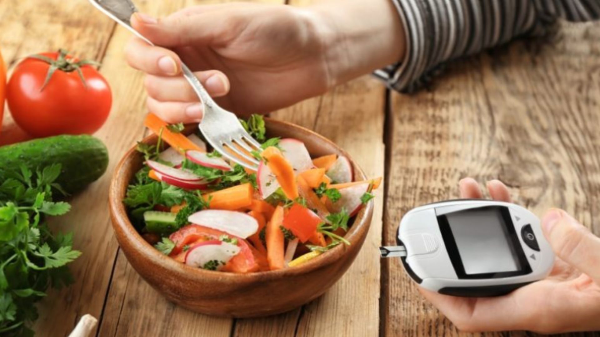 A person holds a spoon in one hand and a digital blood sugar meter in the other, preparing to check their glucose levels.