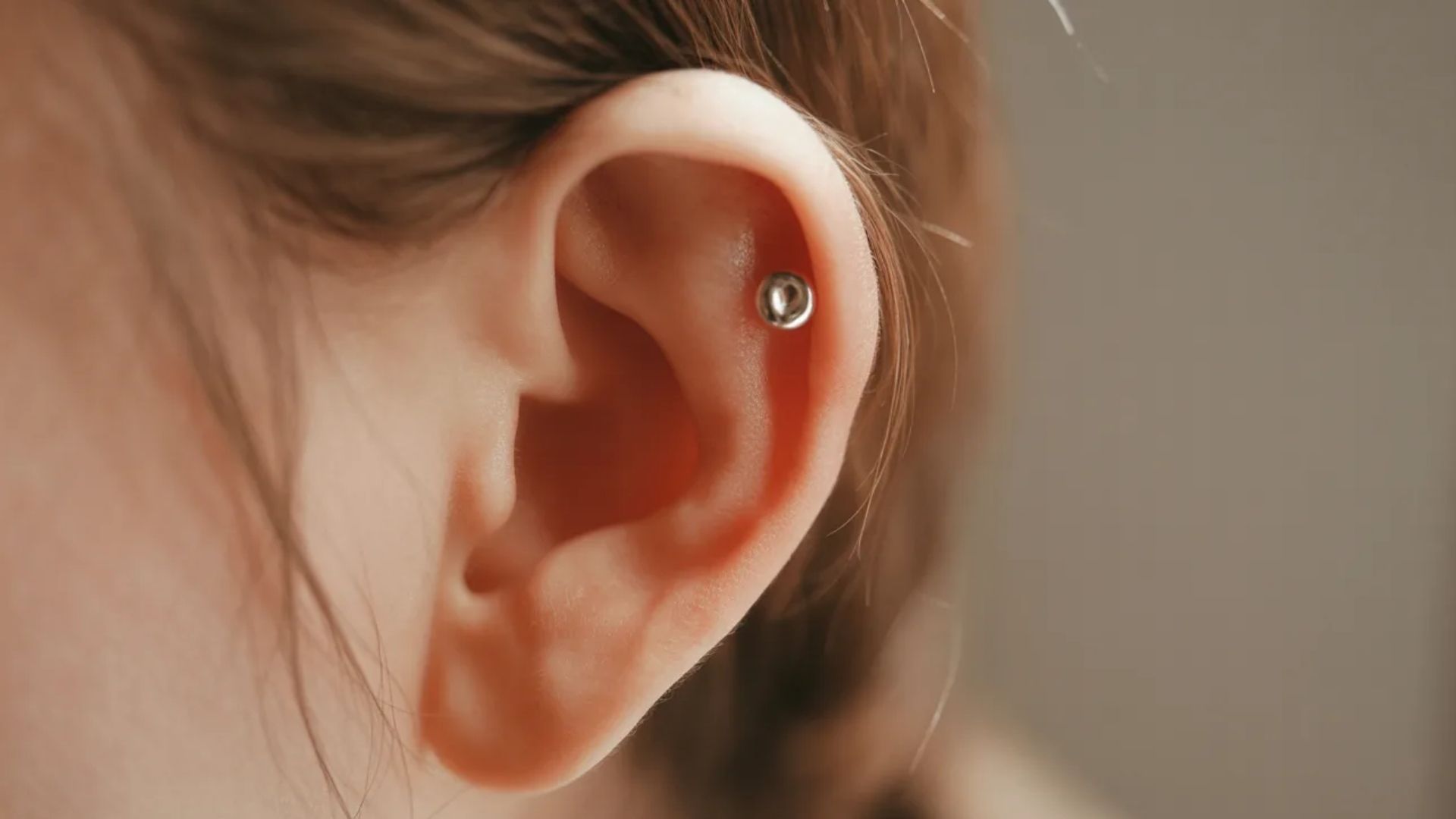 A woman with a visible ear piercing, reflecting her personal style and aesthetic preferences.