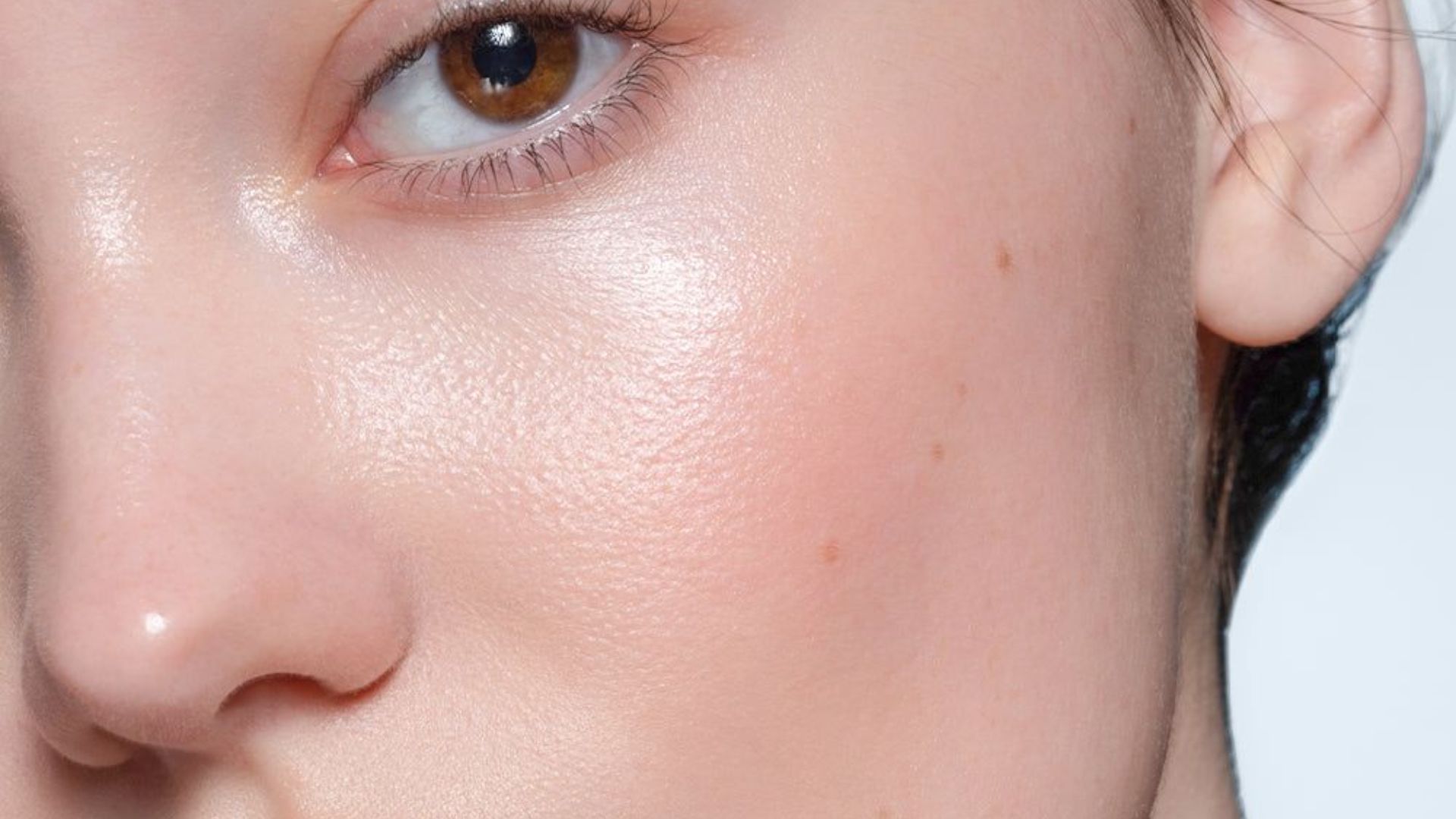 Close-up of a woman's face against a white background, highlighting her features and expression.