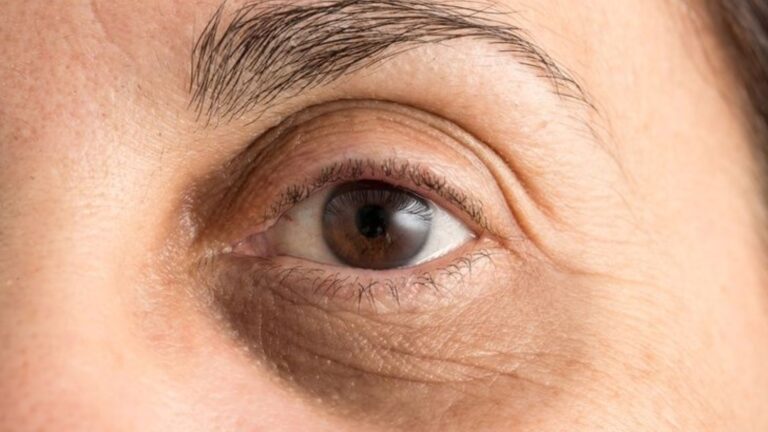 Close-up of a woman's eye, showcasing intricate details of the iris and eyelashes.