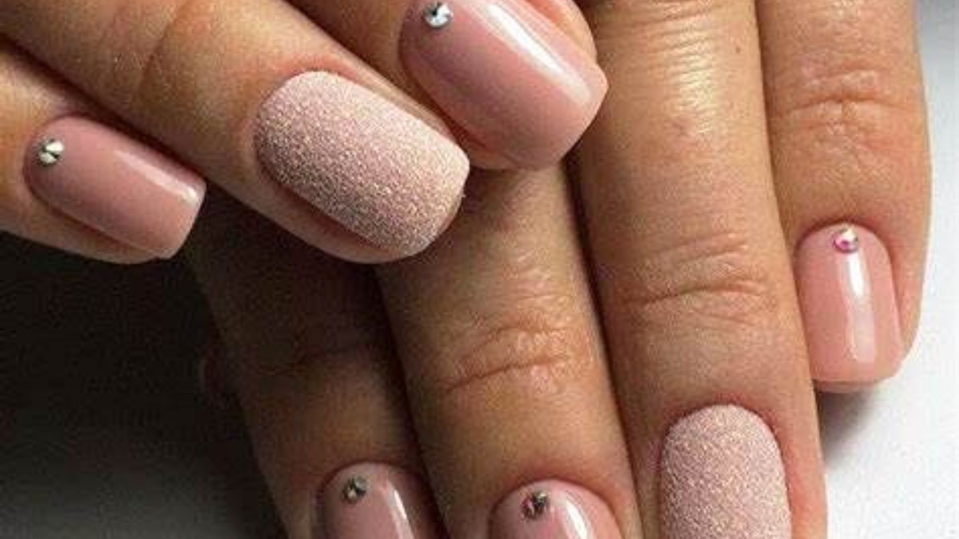 Elegant nail art designs featuring intricate patterns adorned with sparkling diamonds.