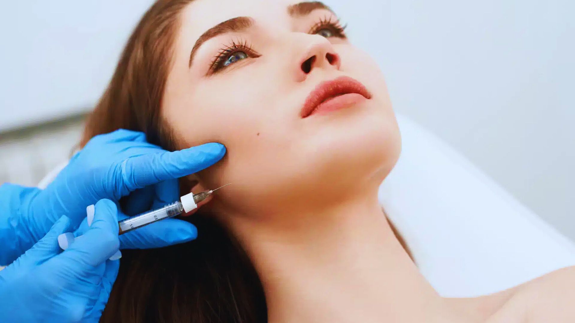 A women undergoing facial surgery, focusing on the jaw area, possibly for masseter treatment with Dysport or Botox