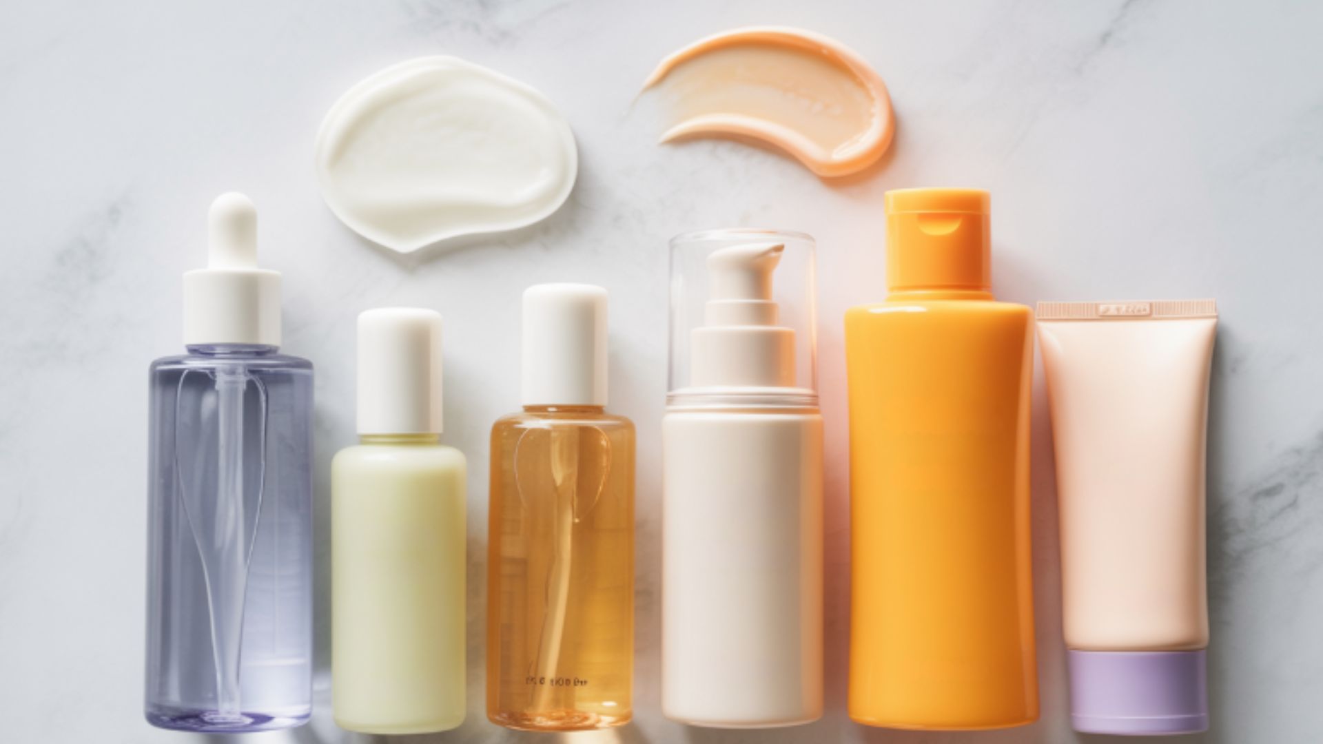 Skincare products displayed on a marble surface, illustrating the correct order of toner and serum application.