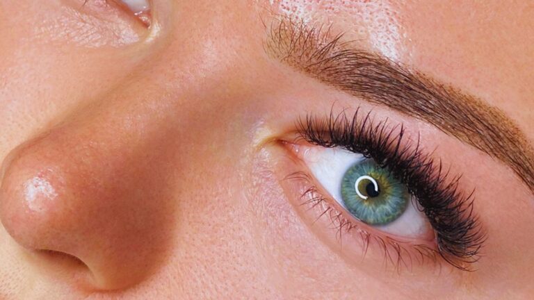 Detailed view of a woman's eye with striking long eyelashes, highlighting the texture of the iris