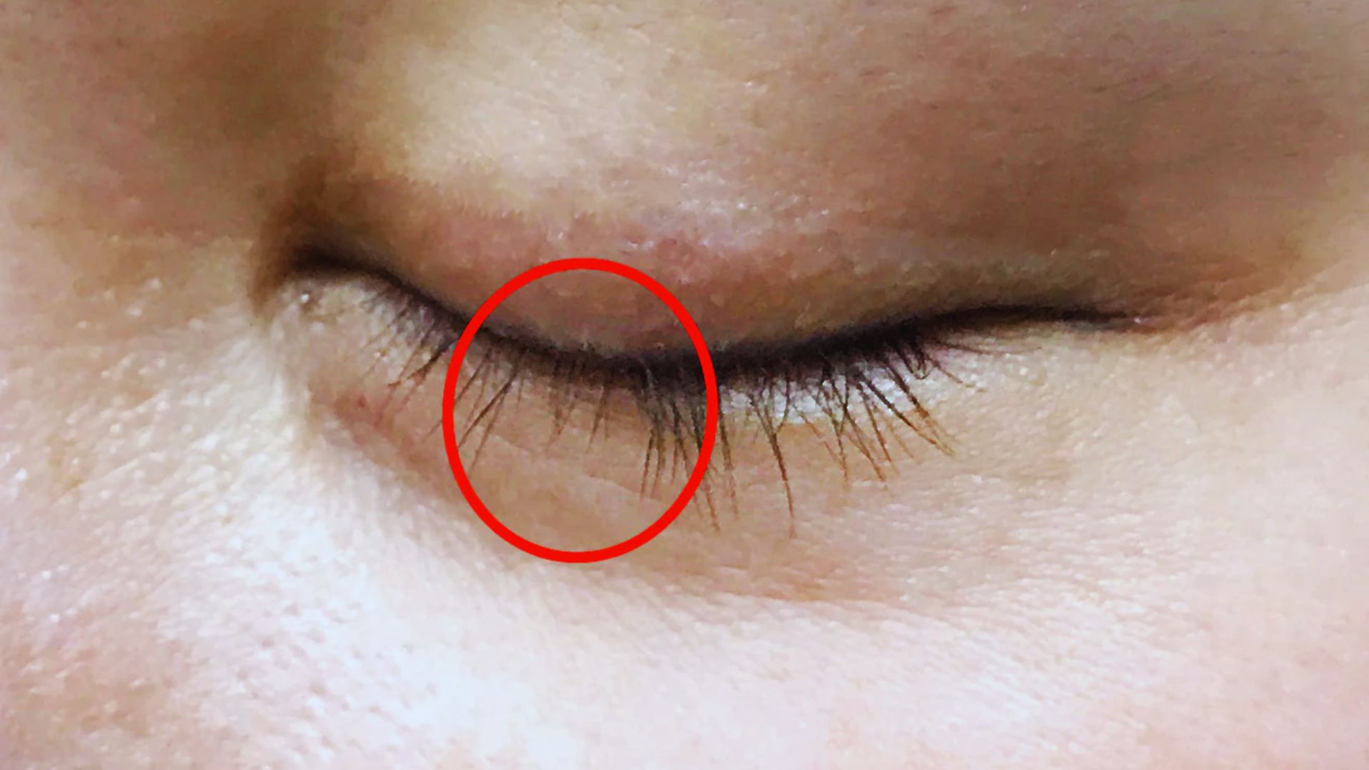 A close-up of a woman's eye surrounded by a bold red circle, emphasizing the eye's features and expression.