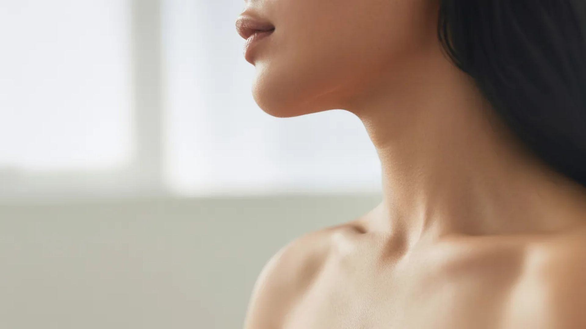 4.A woman with long hair poses without a shirt, exuding confidence and self-expression.
