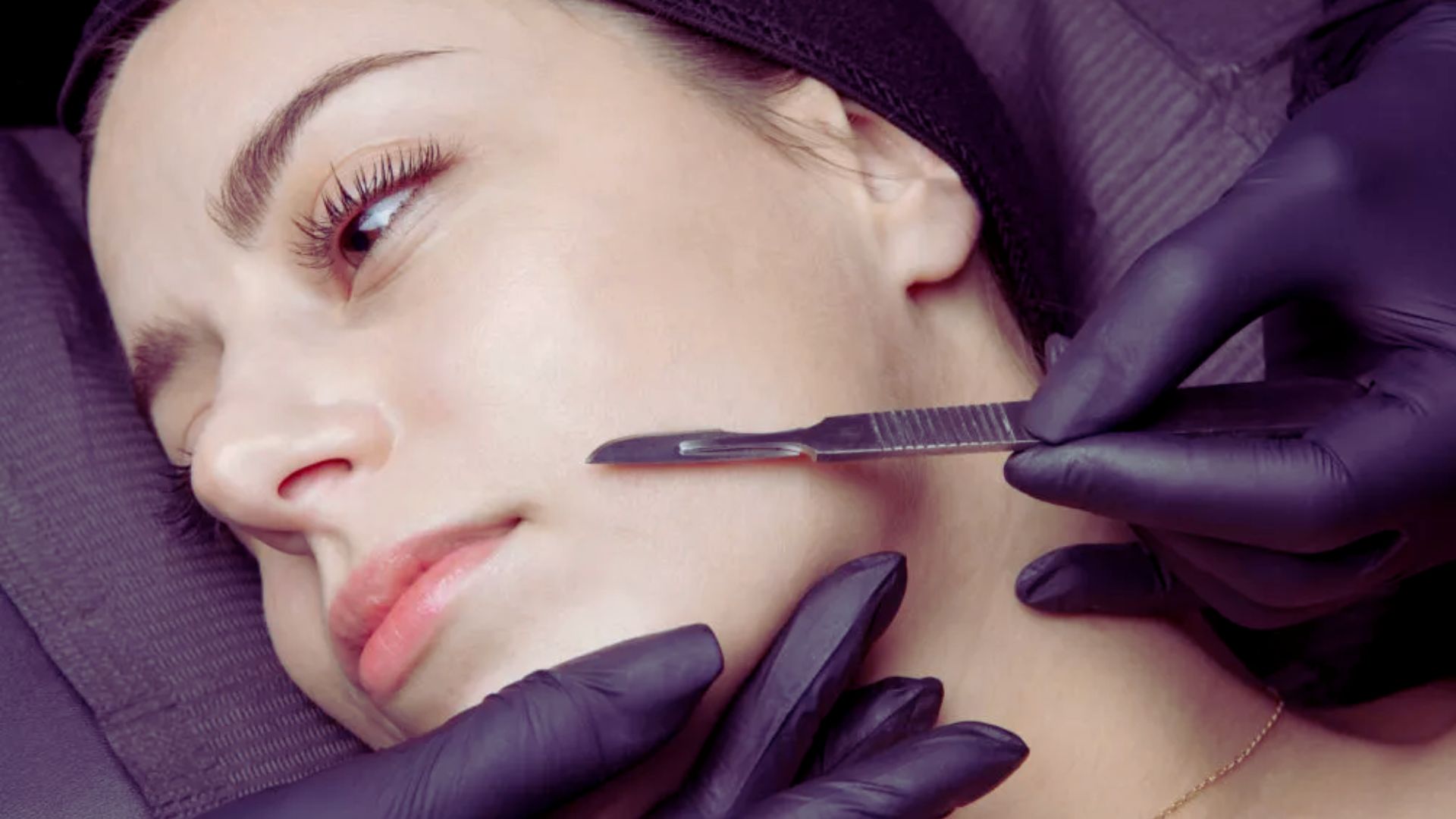 A woman receiving a facial treatment while a professional uses scissors for precise grooming.
