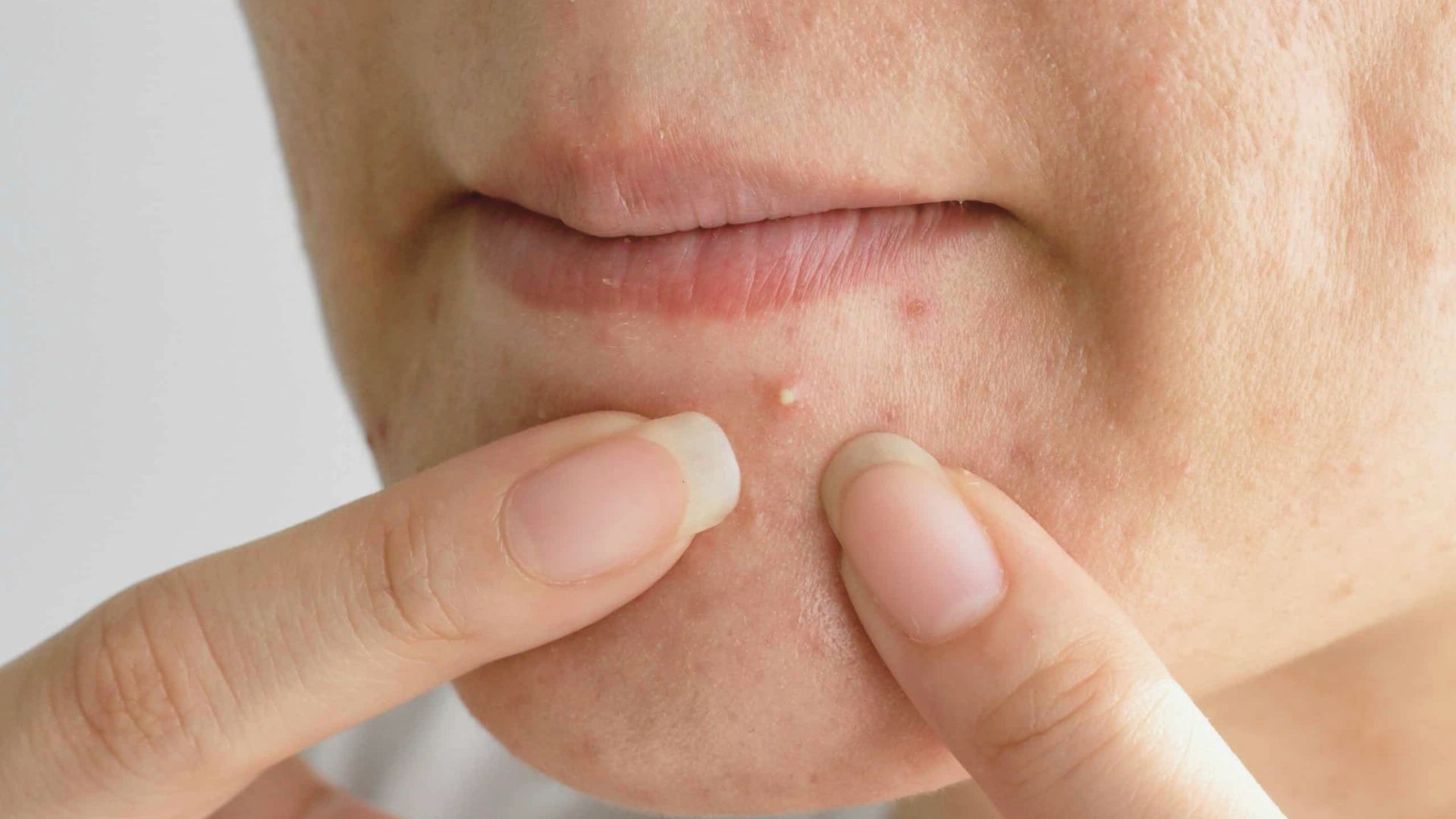 A woman gently touches her lips with her finger, appearing contemplative or thoughtful.