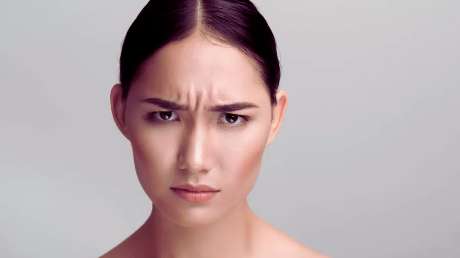 A woman with a frown, expressing displeasure or concern.