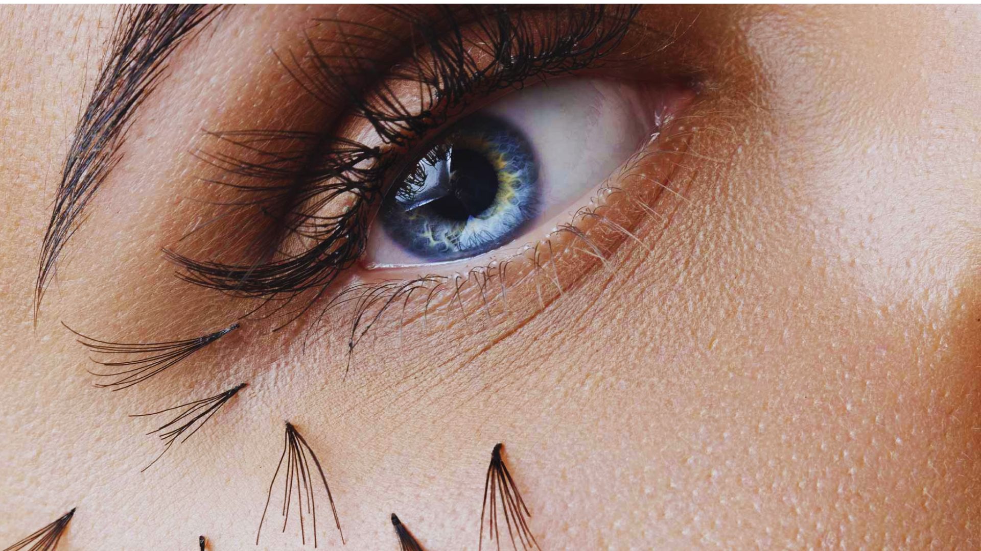 A close-up of a woman's eye showcasing long eyelashes and detailed iris patterns.