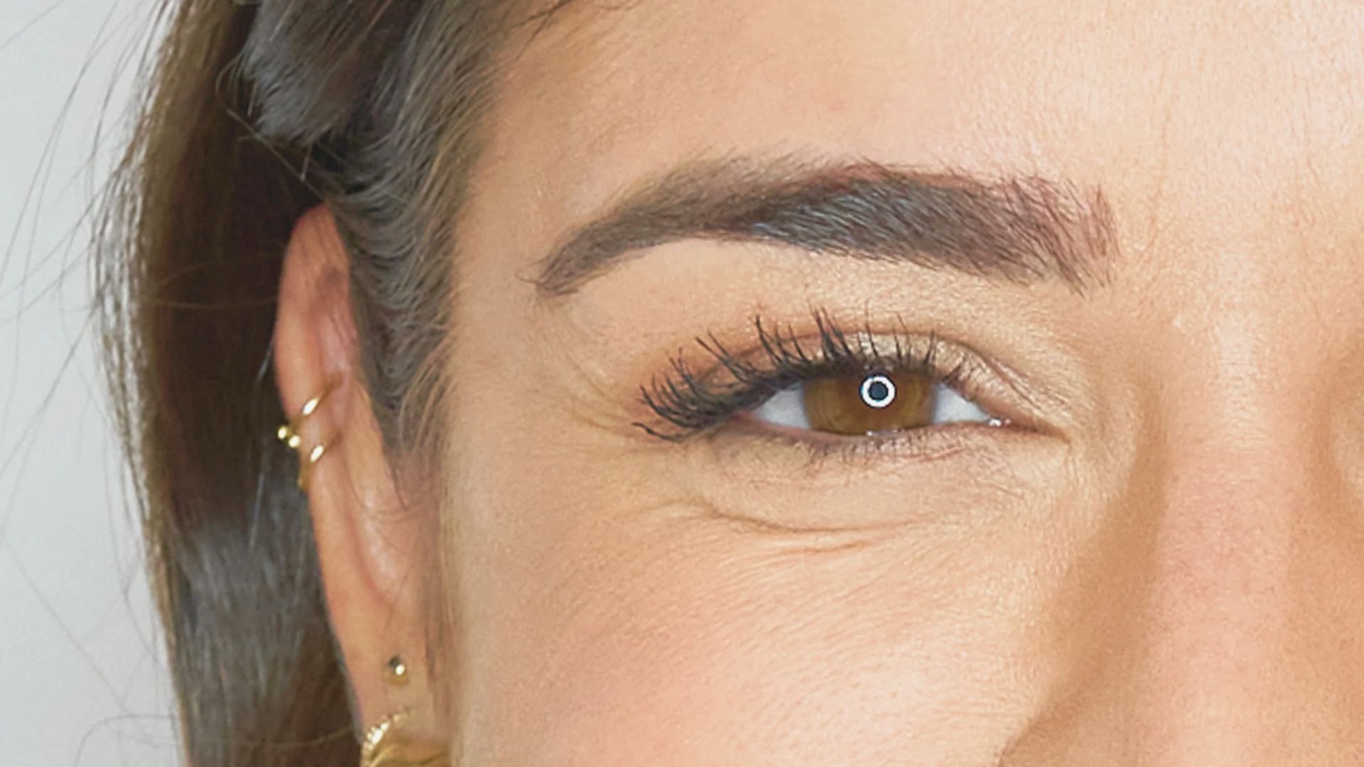 A woman's face fills the frame, her big smile conveying happiness and positivity in a close-up shot.