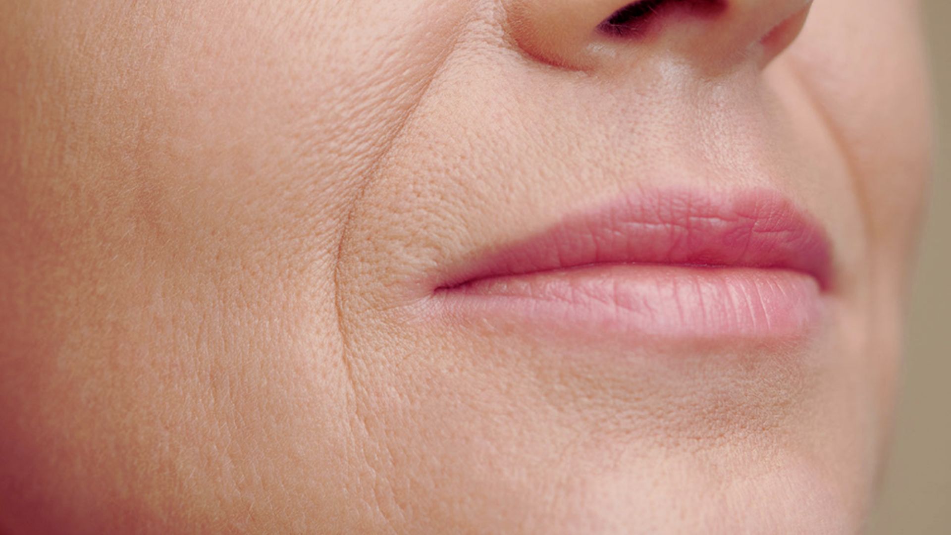 Close-up of a woman's face showing deep wrinkles, highlighting her age and life experiences.