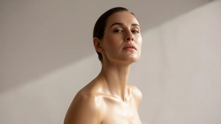 A woman wrapped in a white towel gazes upward, her expression thoughtful and serene.