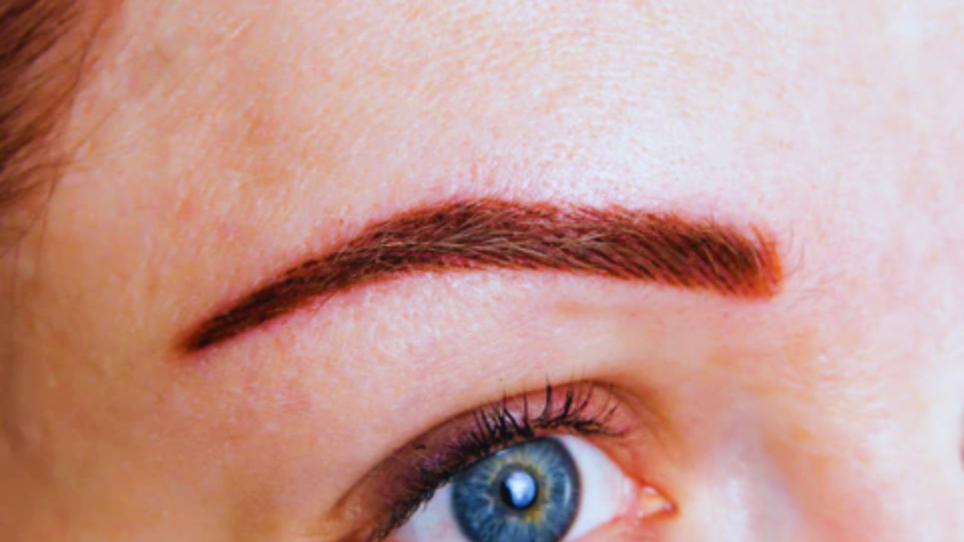 A woman's eyebrow with a brown eyebrow pencil applied, showcasing a well-groomed and polished appearance.