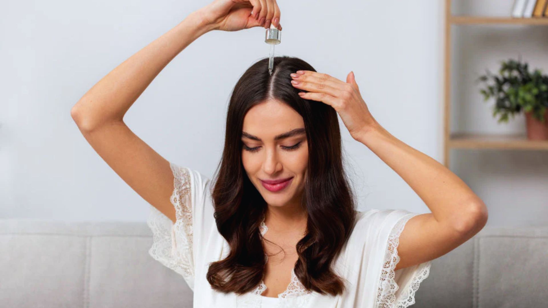 A woman is using a comb to brush her hair, focusing on her grooming routine.