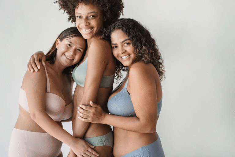 Three women in underwear pose together for a photo, showcasing confidence and camaraderie.