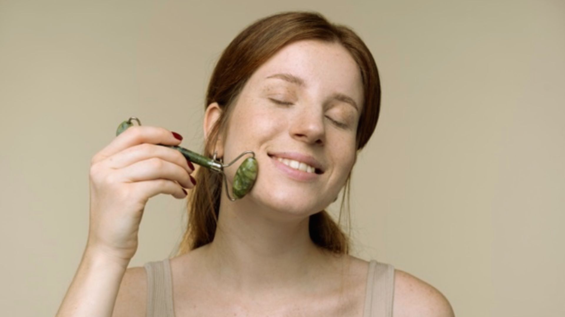 A woman is brushing her teeth with a toothbrush in a bright bathroom setting.
