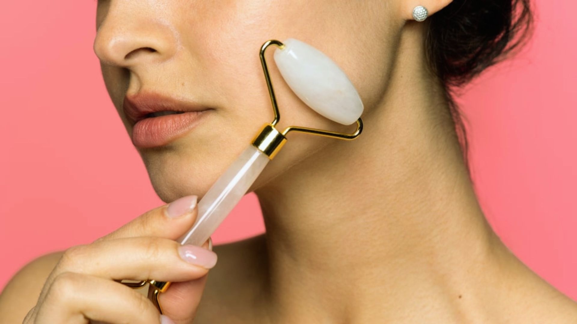 A woman gently applies a facial brush to her face, focusing on her skincare routine.