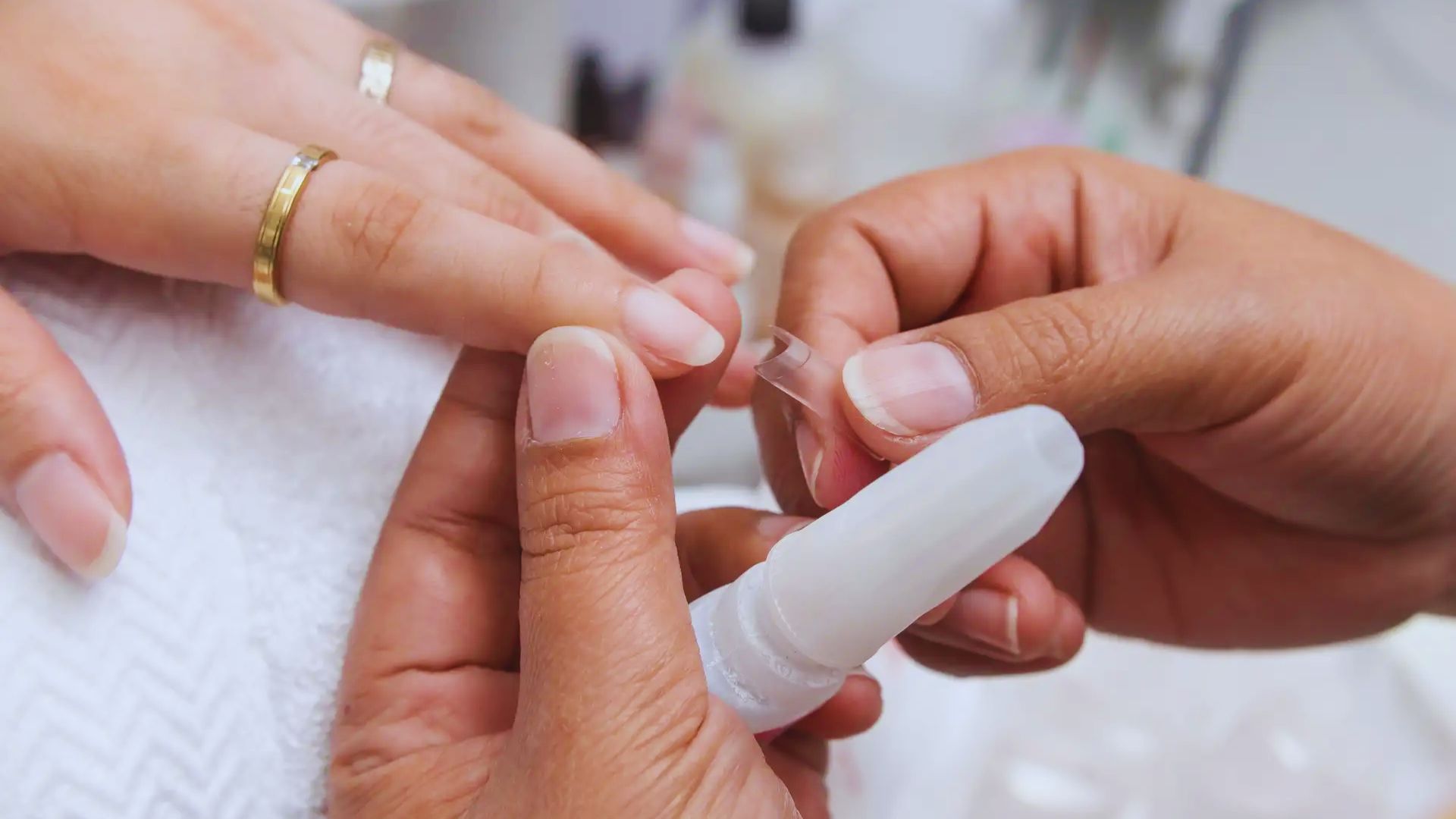 A person filing their nails at a salon, focusing on nail care and grooming.