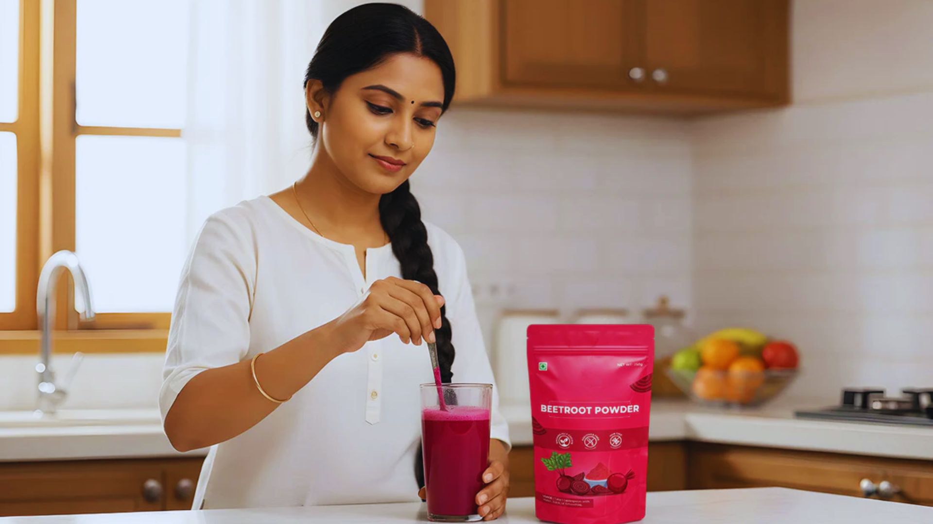 A woman blends a smoothie using a bag of juice, surrounded by fresh fruits on the kitchen counter.