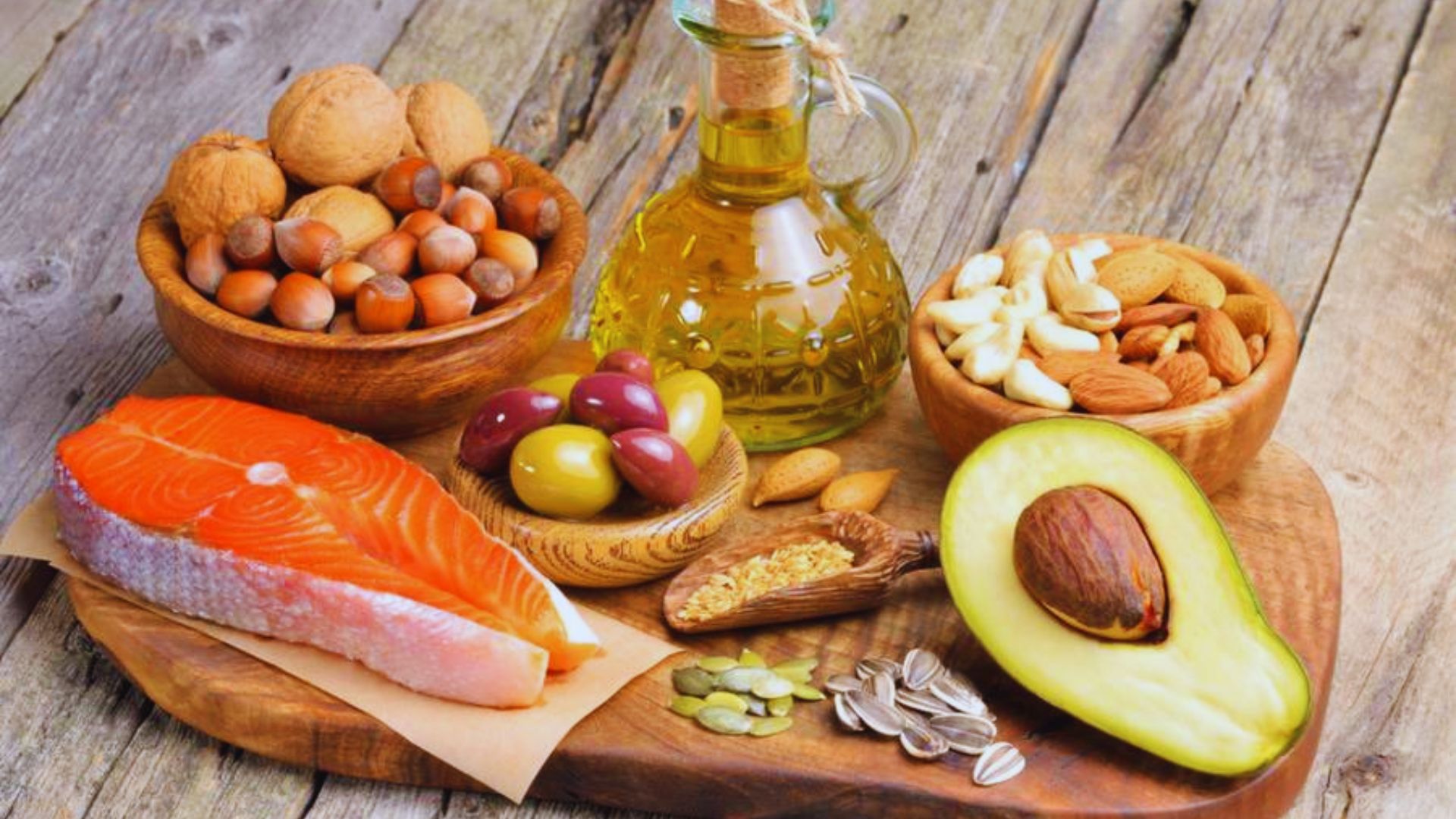 A variety of healthy foods for weight loss, including fruits, vegetables, lean proteins, and whole grains on a wooden table.