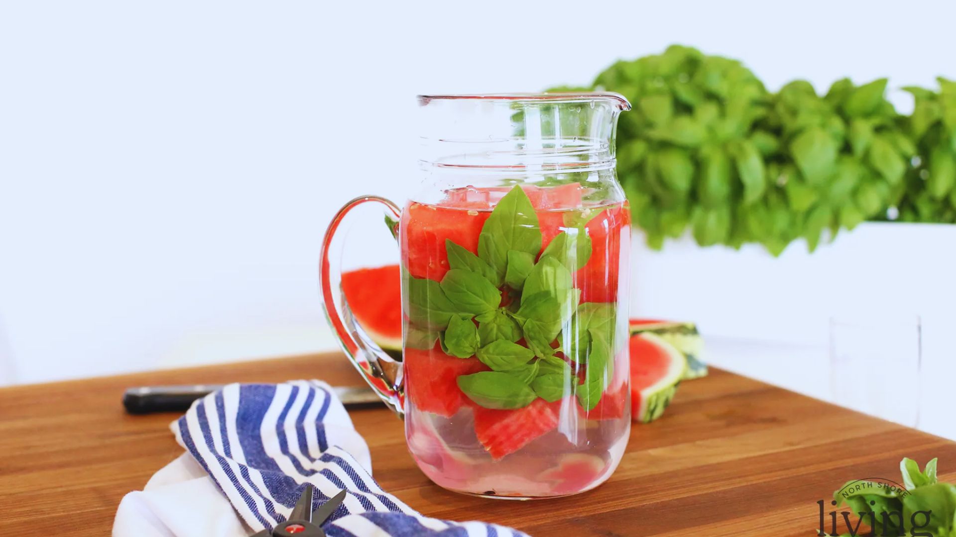 A clear pitcher filled with refreshing watermelon chunks and vibrant green mint leaves.