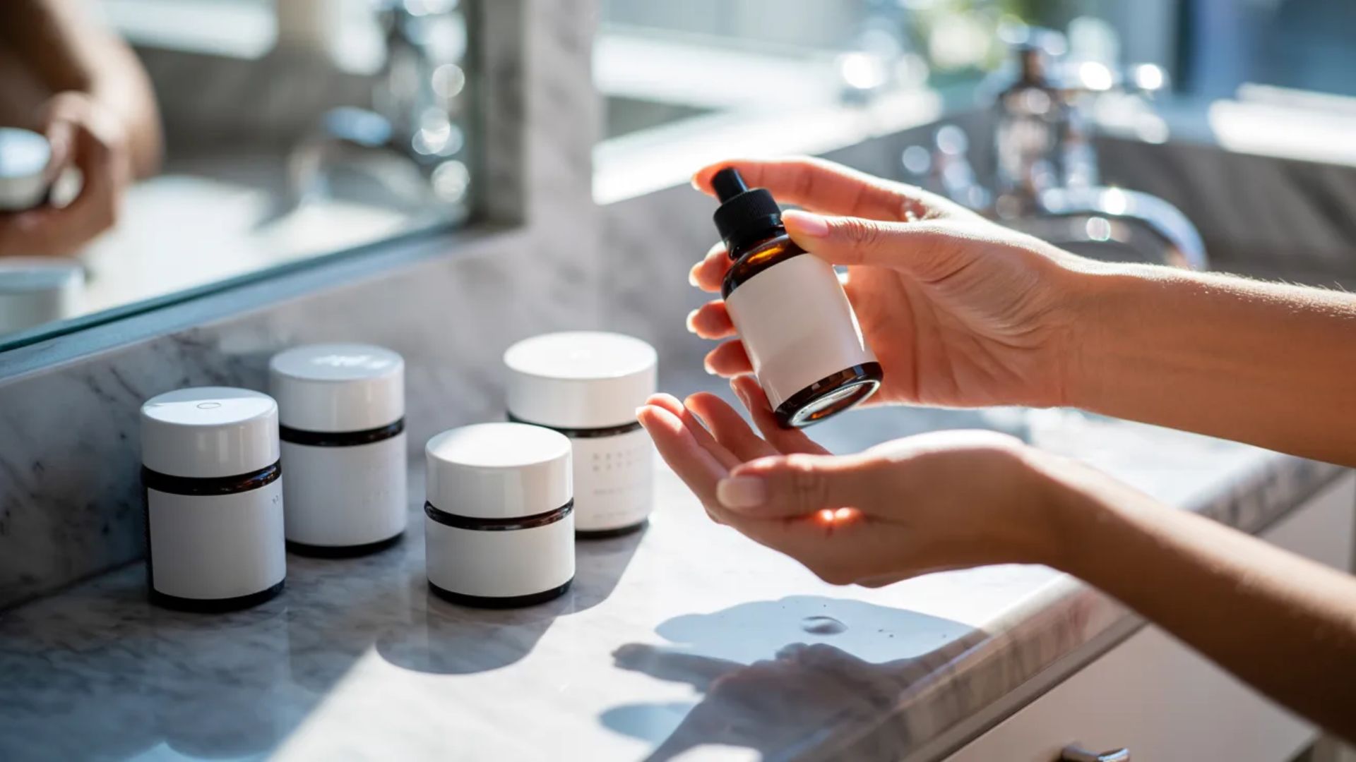 A person holds a small bottle of essential oils, showcasing its label and the person's hand in a natural setting.