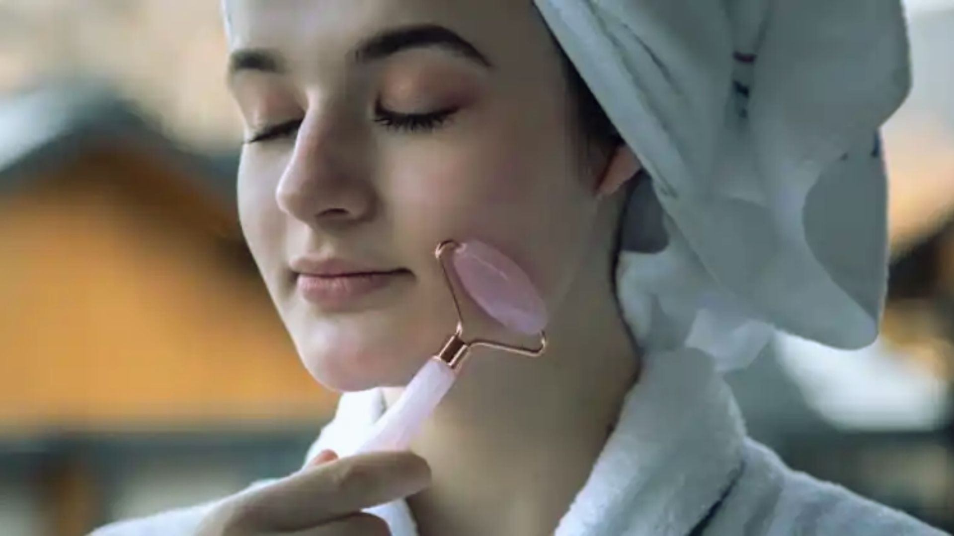 A woman wrapped in a towel brushes her hair with a pink brush, focusing on her grooming routine.