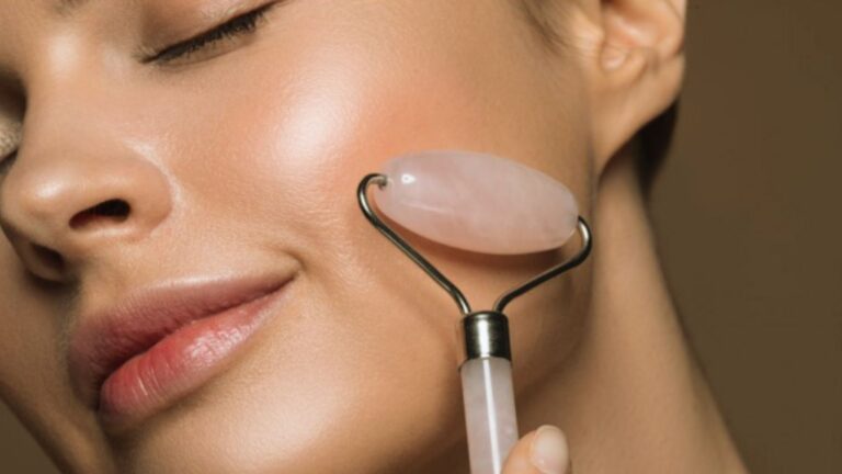 A woman gently cleanses her face using a rose quartz stone, promoting relaxation and skincare.