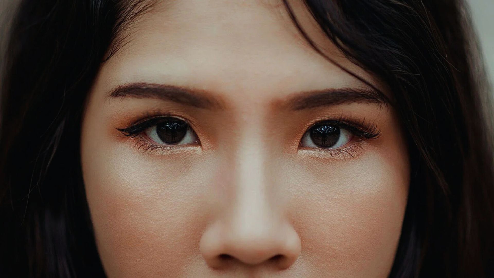 Close-up of a woman's face, showcasing her features and expression with soft lighting.