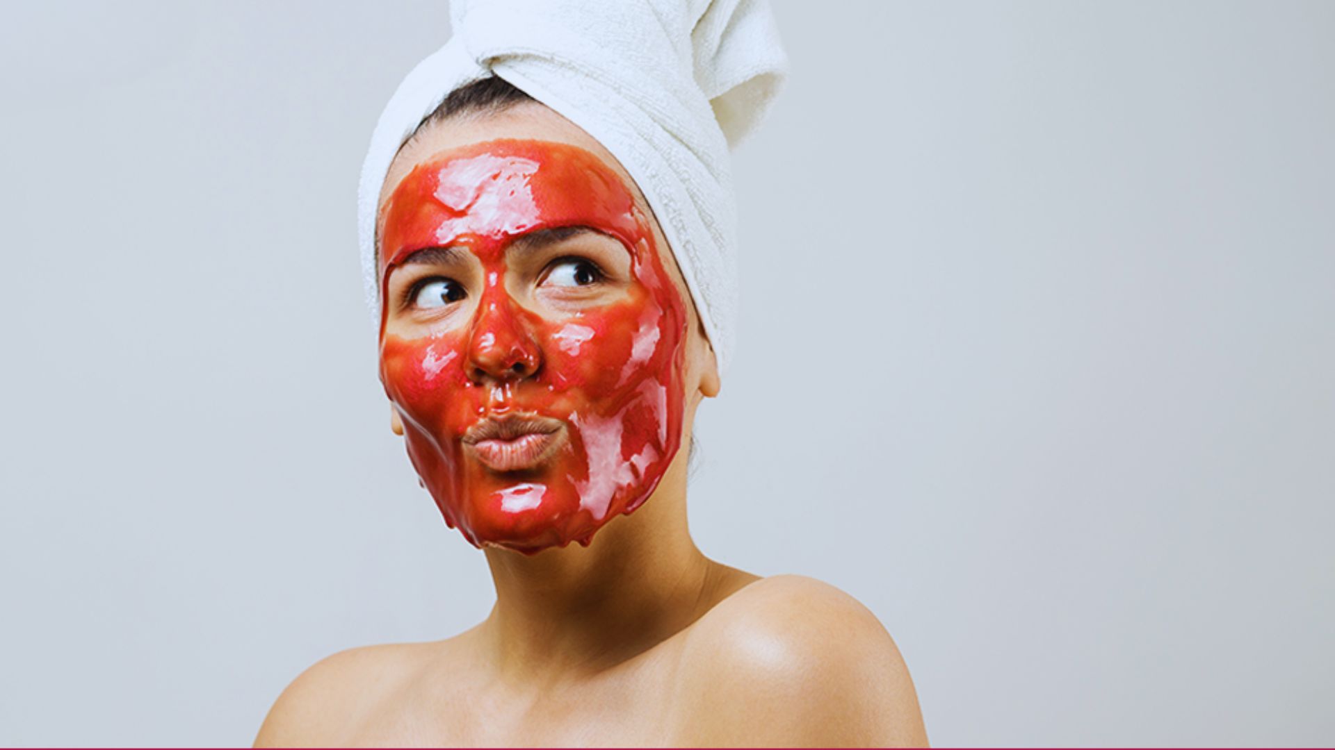 A woman wearing a red face mask on her head, showcasing a vibrant accessory in a casual setting.