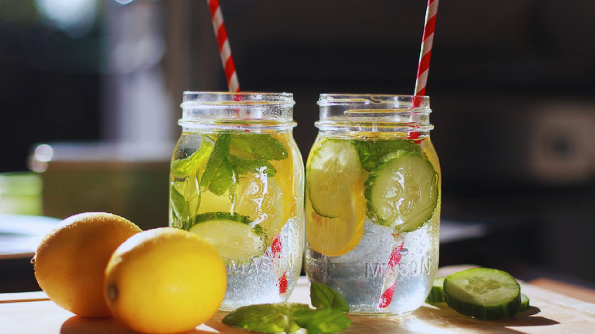 Two jars filled with refreshing lemonade and garnished with cucumber slices.