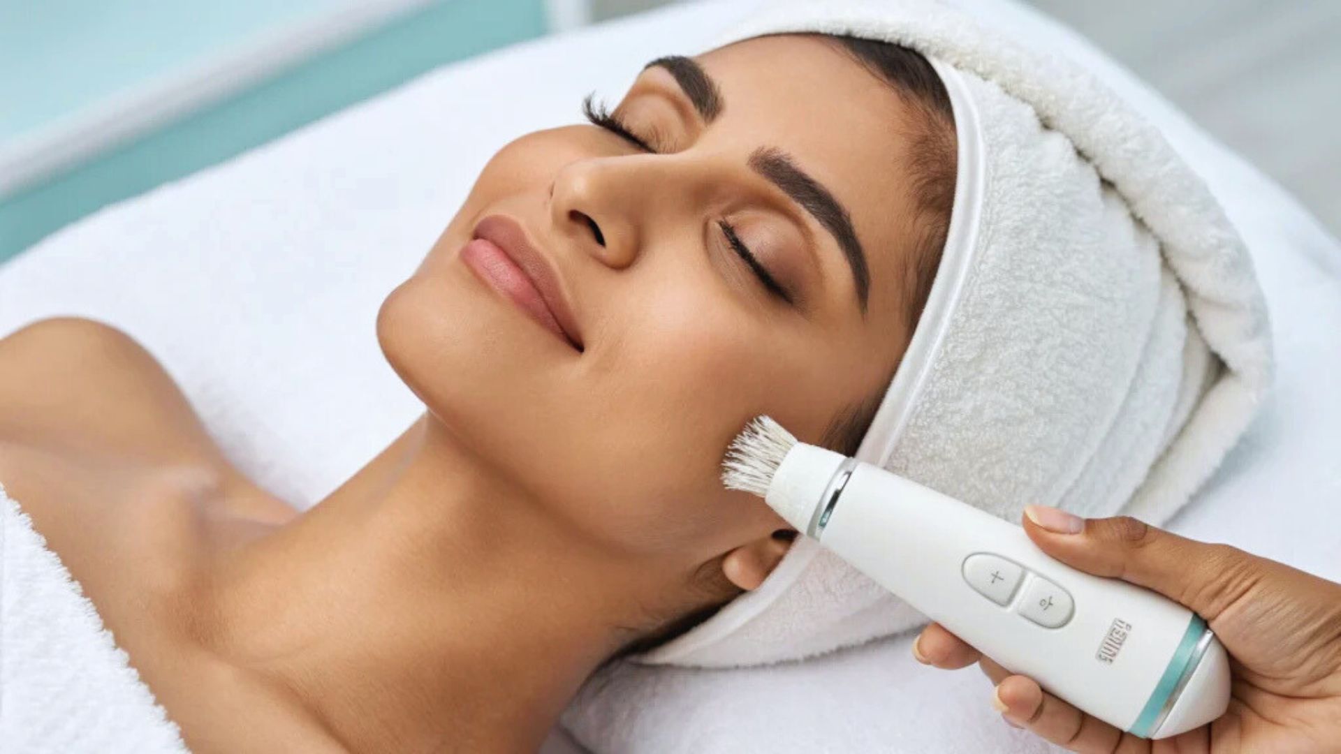 A woman receives a facial treatment using an electric device in a serene spa setting.