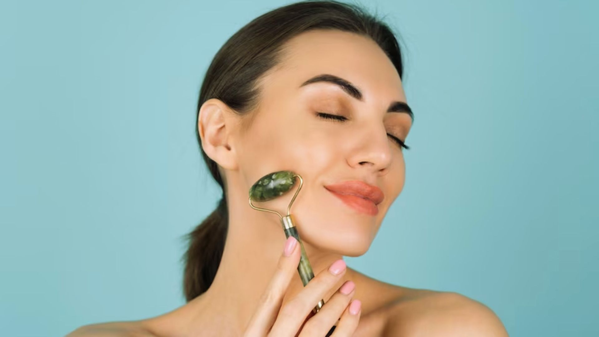 A woman holds a green stone against her face, showcasing its color and texture in a serene expression.