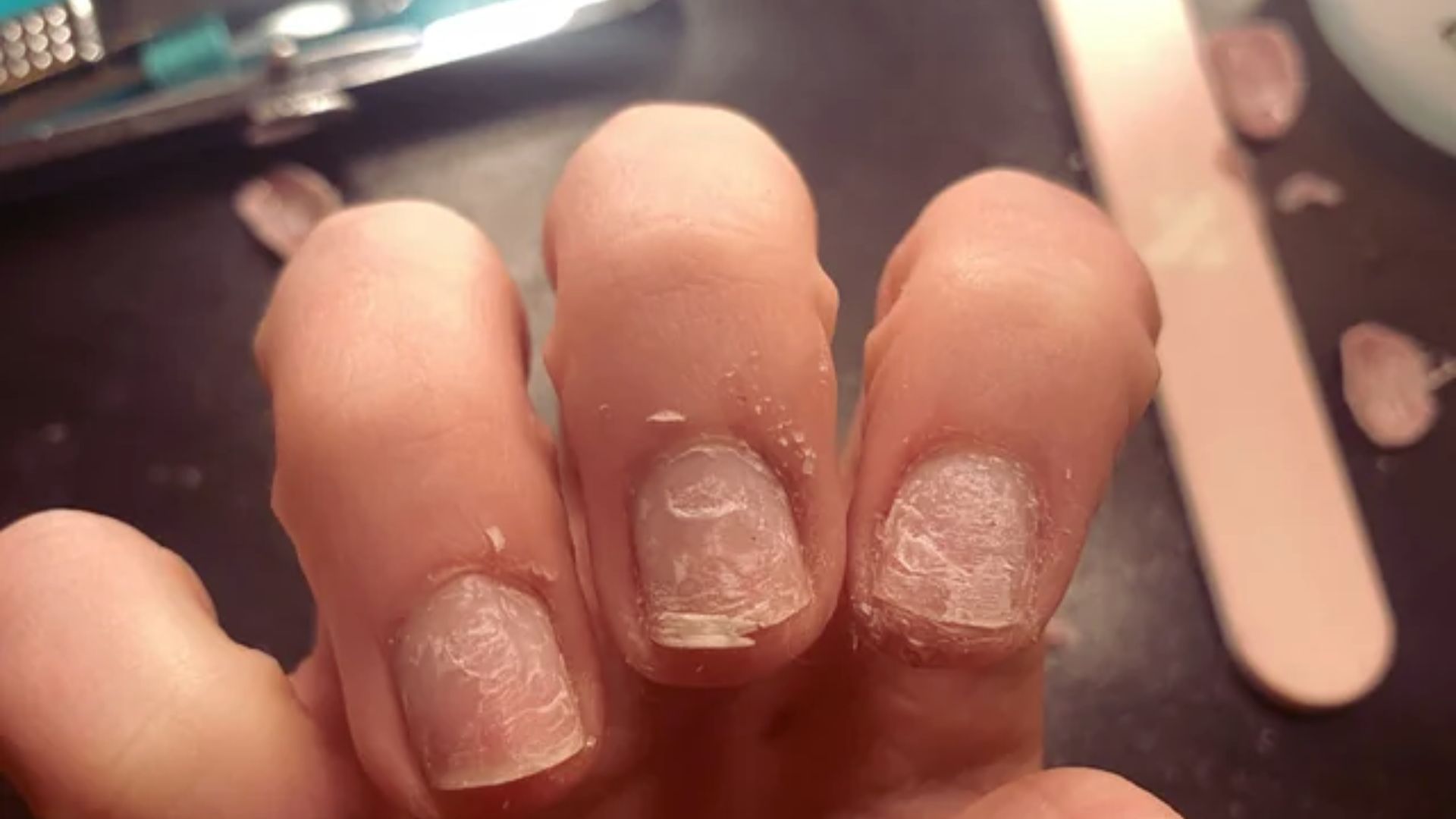 A close-up of a person's hand showcasing white nail polish on their neatly manicured nails.