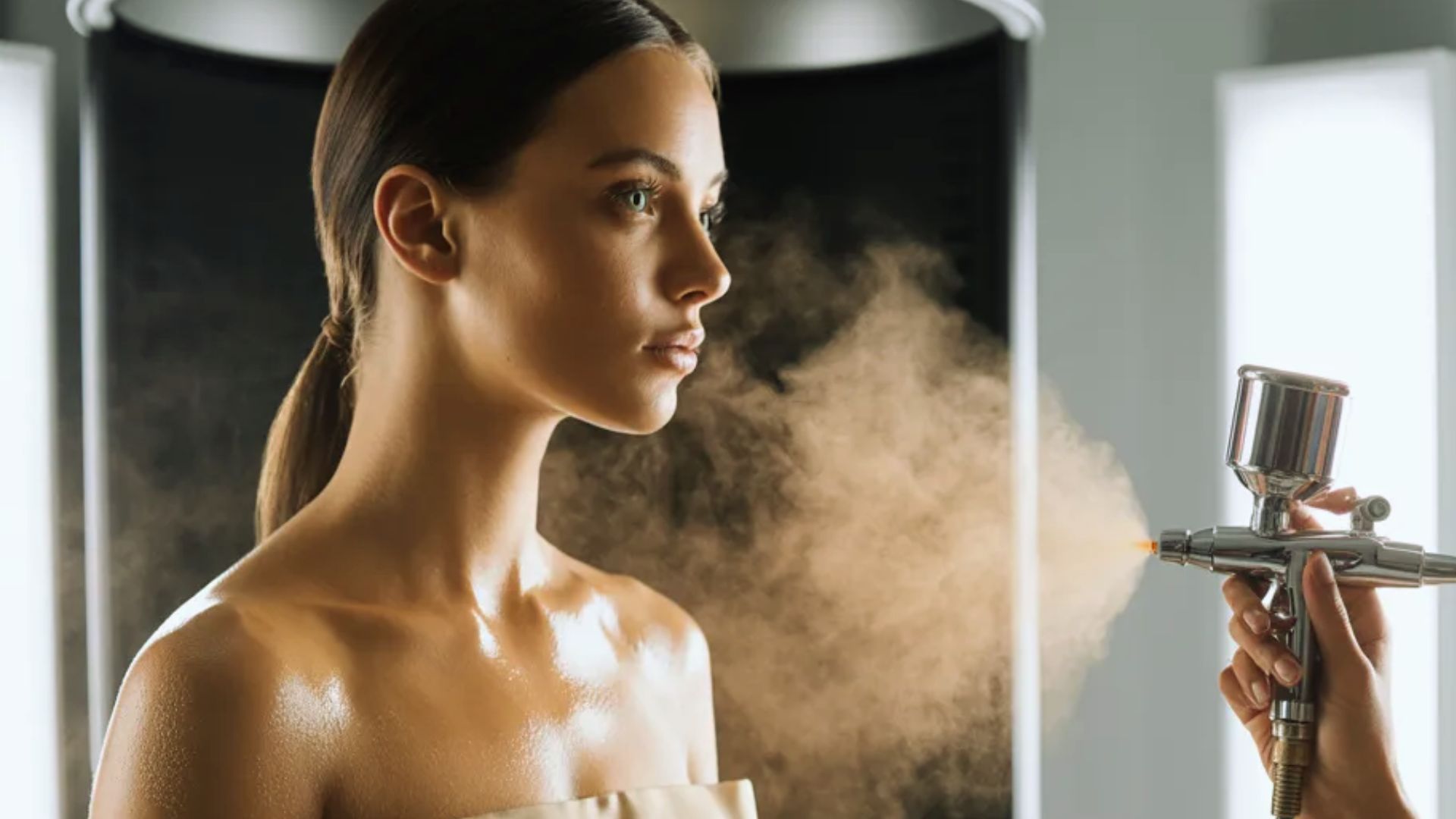 A woman has her hair styled as steam is sprayed onto it, enhancing texture and shine.